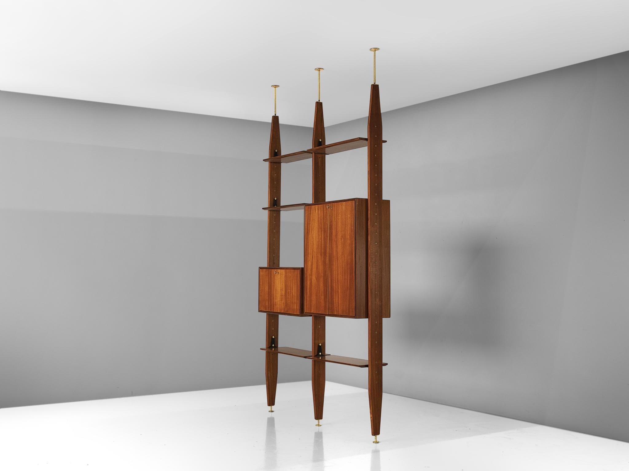 Vittorio Dassi, wall unit book shelf, in walnut and brass, Italy, 1960s.

This book shelf features a three-legged structure that can freely be fixed between the ceiling and the floor. In between the legs the shelves and storage space are adjustable