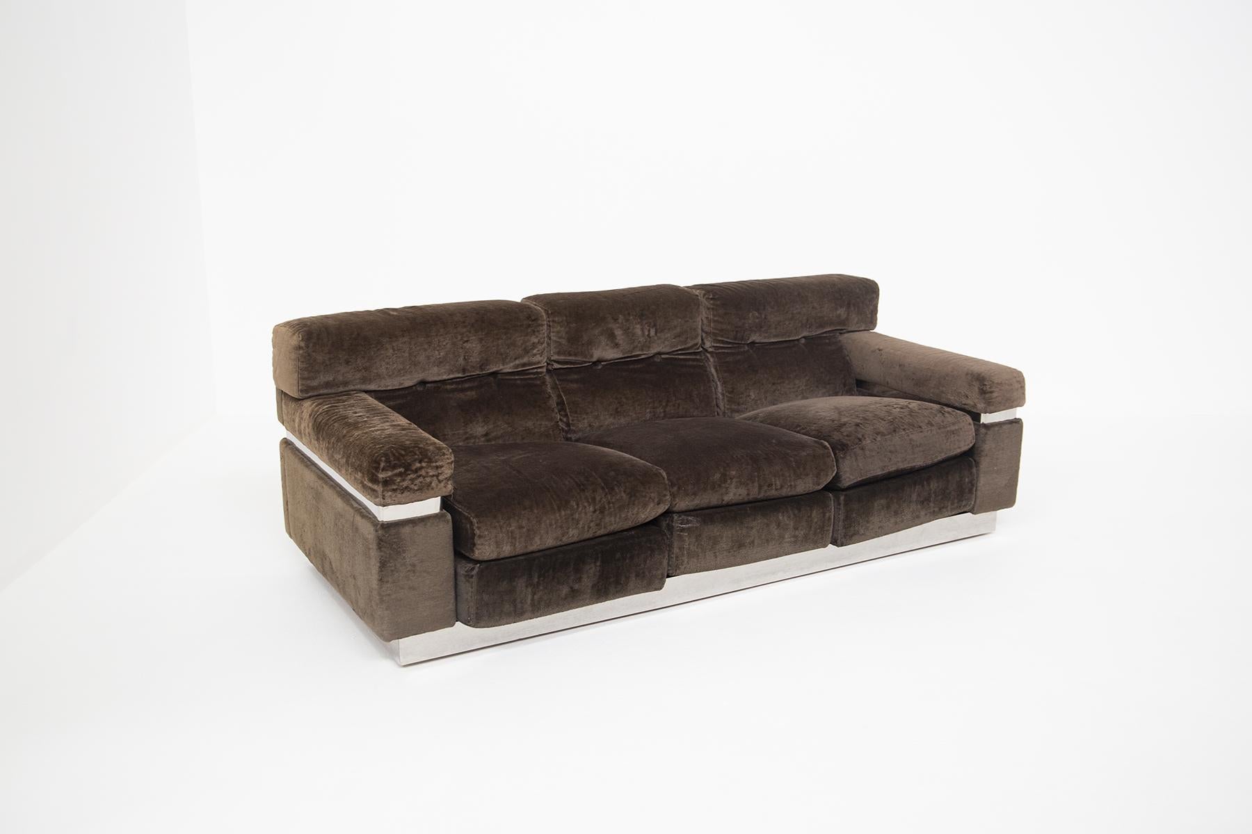 Three seater sofa designed by Vittorio Introini in the 70s. The sofa is made of brown velvet with clean and linear geometric shapes. The sofa has a peculiarity, at the center of the sofa throughout its perimeter has been applied a rectangular steel