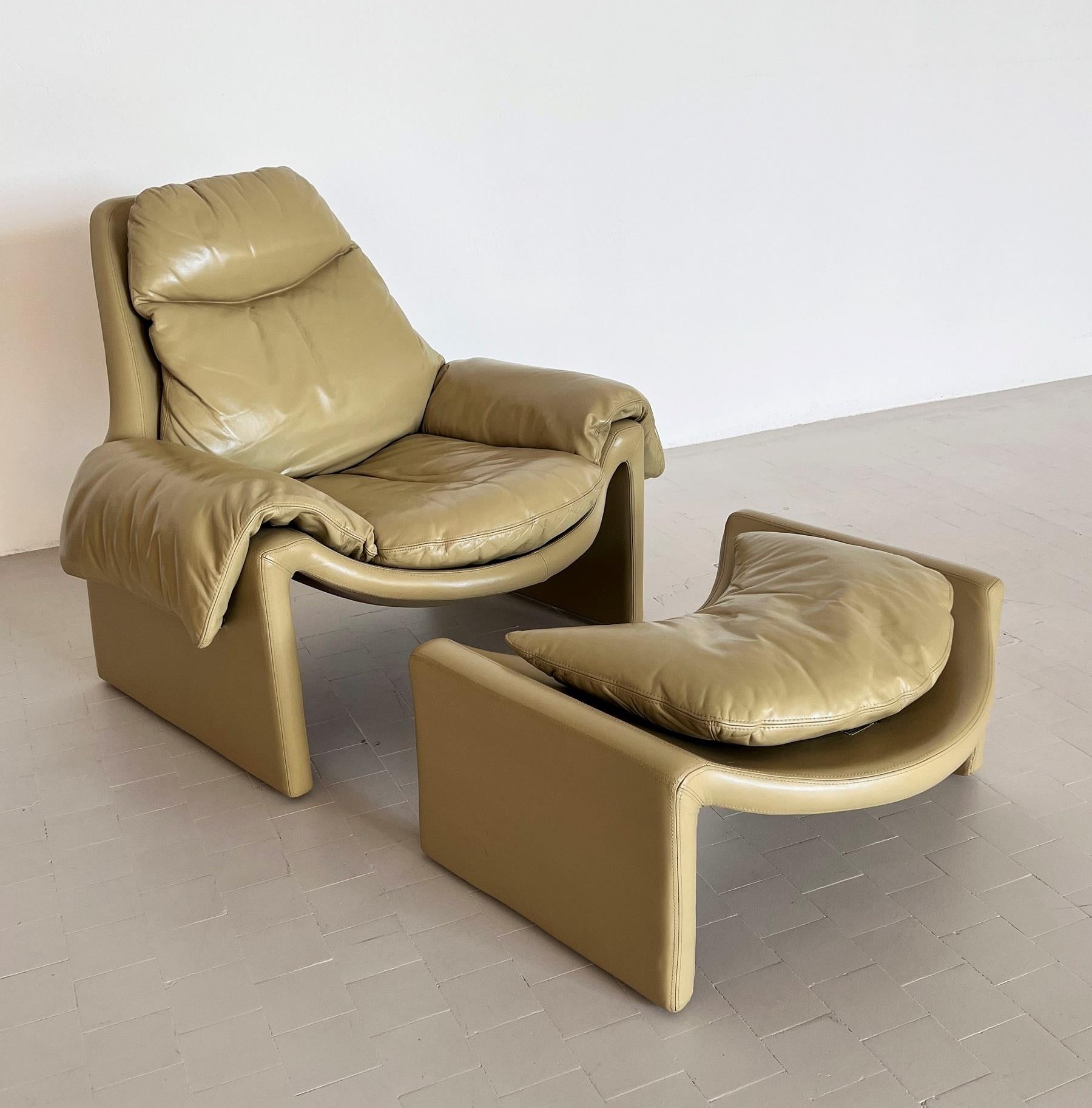 A beautiful and very comfortable set of armchair with saddle effect and matching footstool, which takes the curves of the armchair.
The set has its original pistachio color very smooth leather upholstery. 
Designed circa 1962 by Vittorio Introini