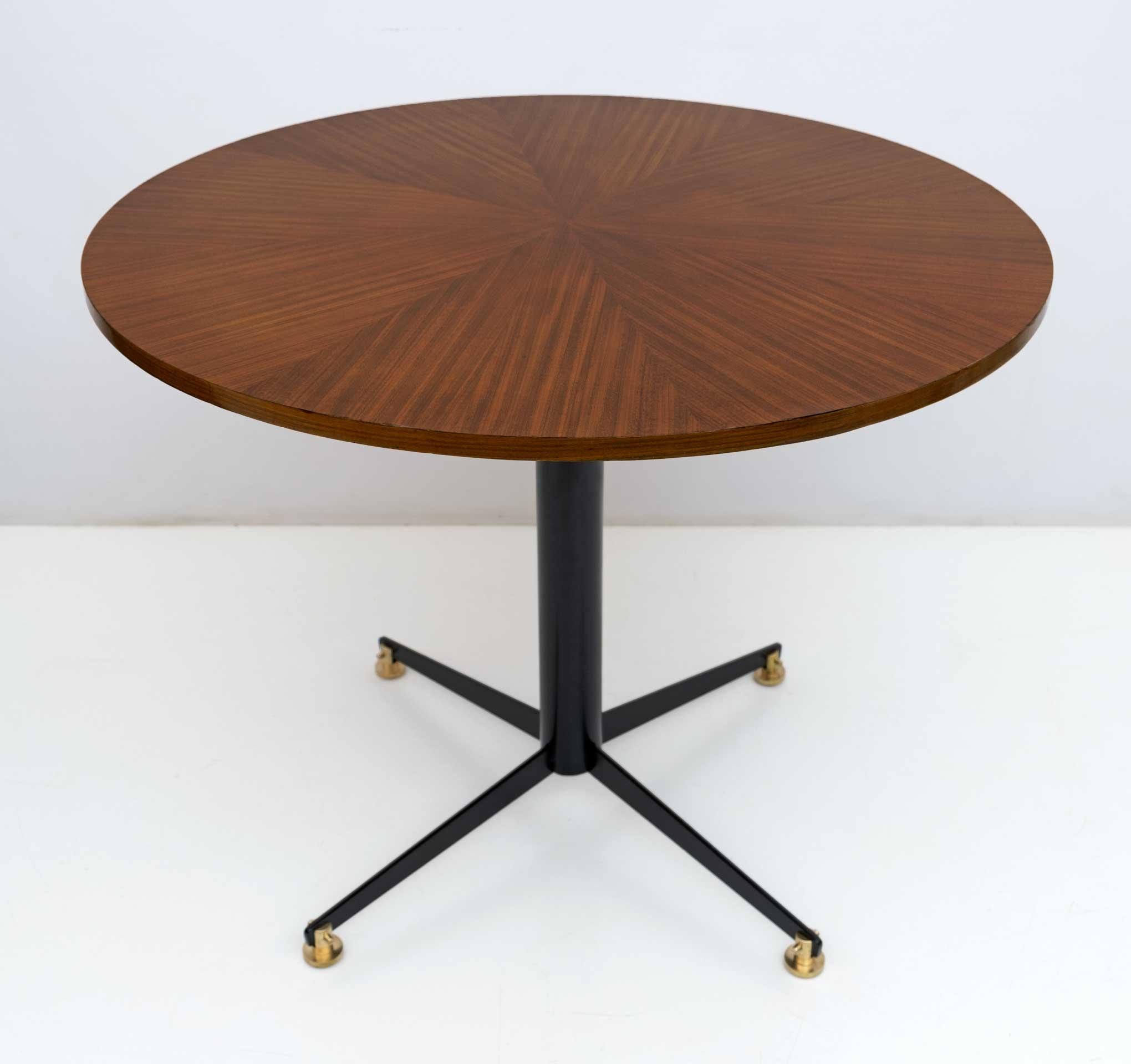 Table produced in the 1950s by Fratelli Tagliabue based on a design by Vittorio Nobili. Base in black painted metal and feet in brass, circular top in herringbone teak veneered wood. Completely restored and ready to decorate your home.