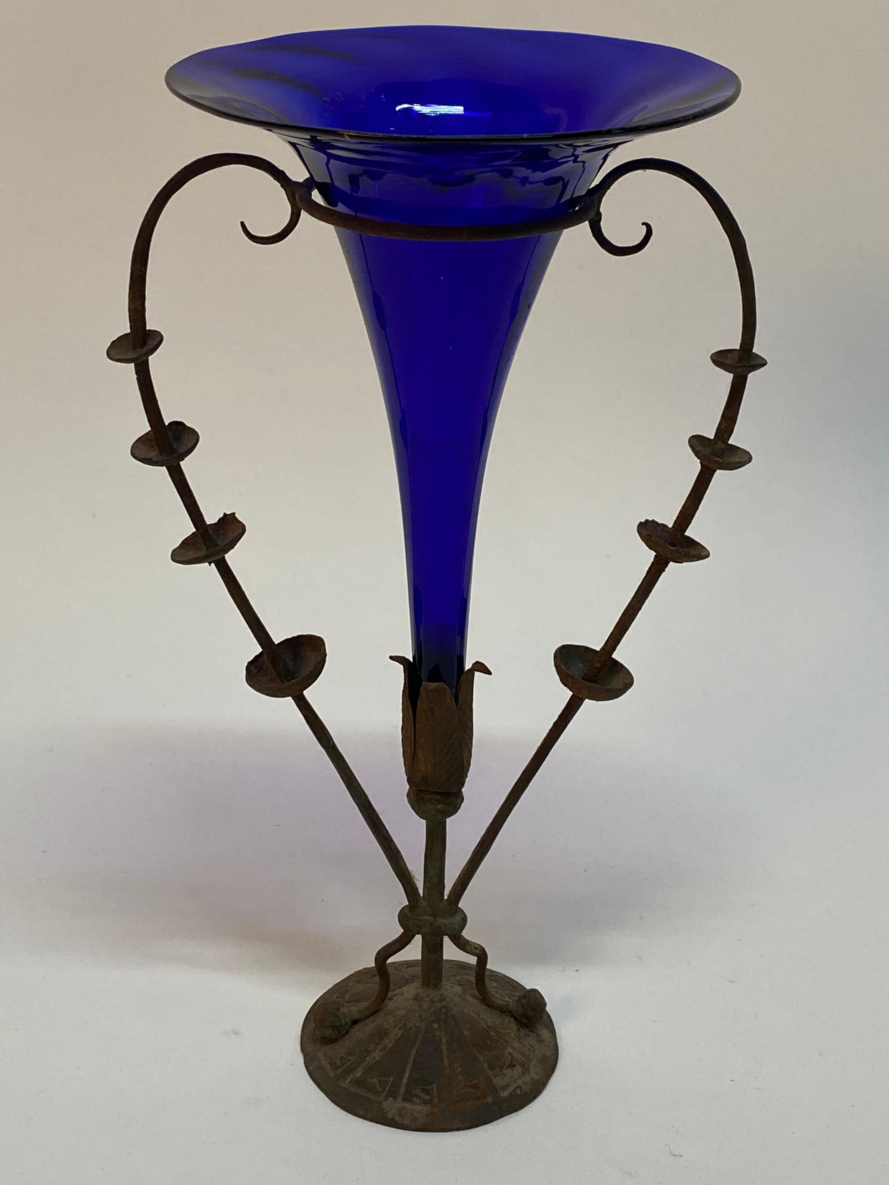 Elegant blown cobalt glass trumpet with a floral iron base. Circa 1920. This form borders on a very late Art Nouveau design, which precedes Zecchin's more modern forms of the late 1940s-1950s. 

Good overall condition with some cosmetic wear, light