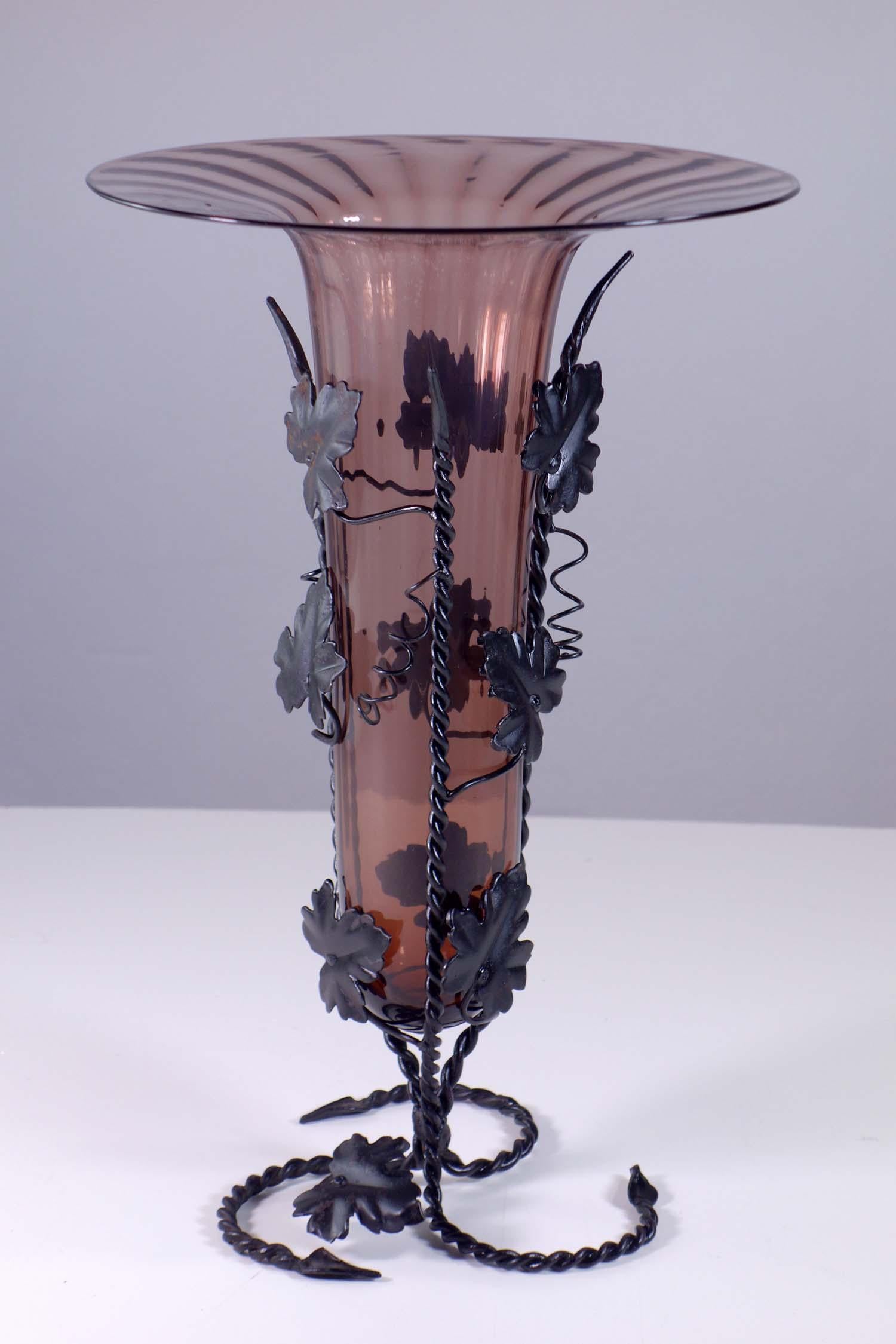 Vittorio Zecchin
Murano, début 1900

Vase en verre soufflé strié d'améthyste
Cadre de vigne en fer forgé

Excellente condition
(petit défaut sur une feuille)