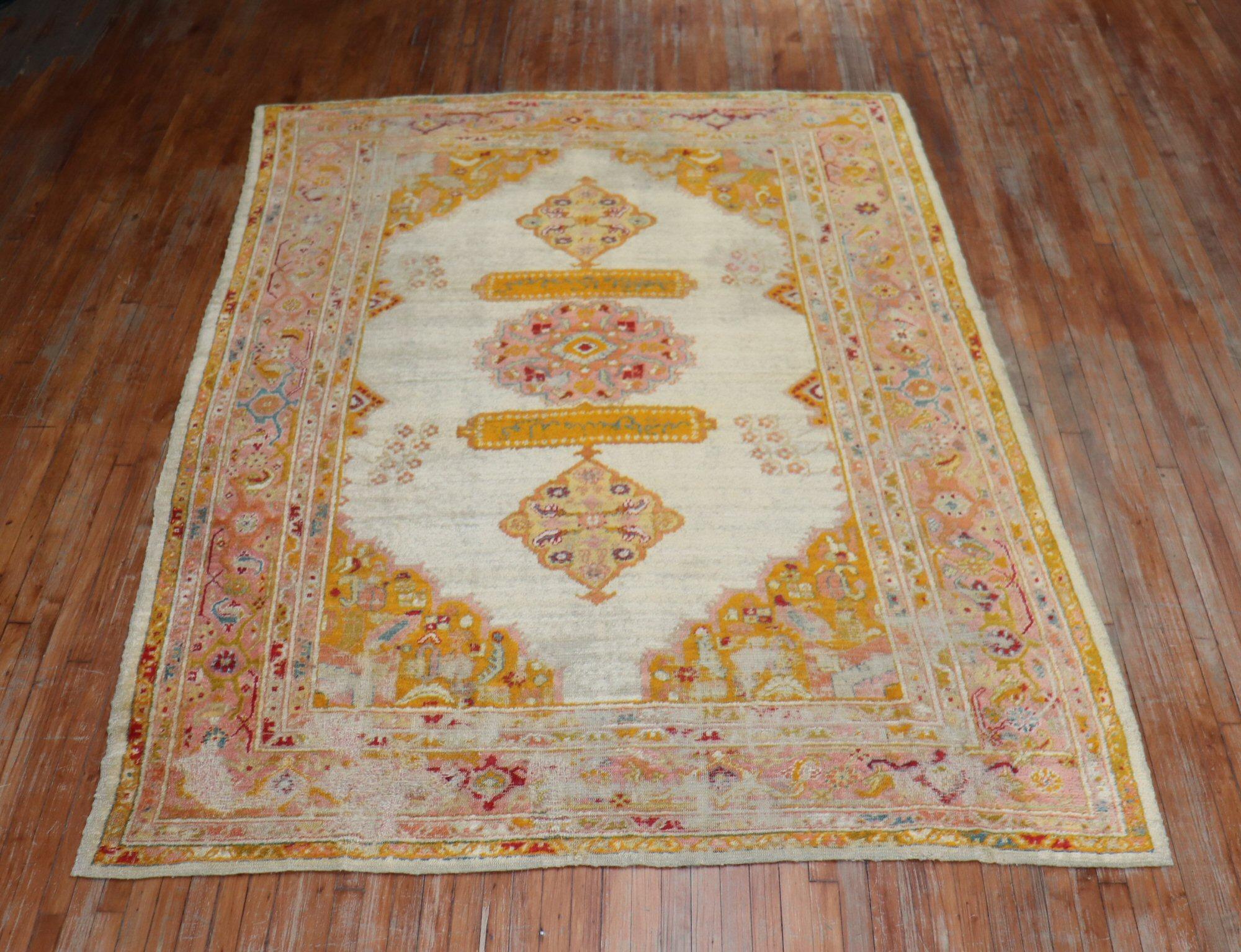 Late 19th century shabby chic Angora Oushak rug with saturated colors, on an ivory field.

Measures: 7'4” x 10'

Oushak rugs are prized for their rich looks as well as for their high quality and exceptional beauty, which makes them excellent