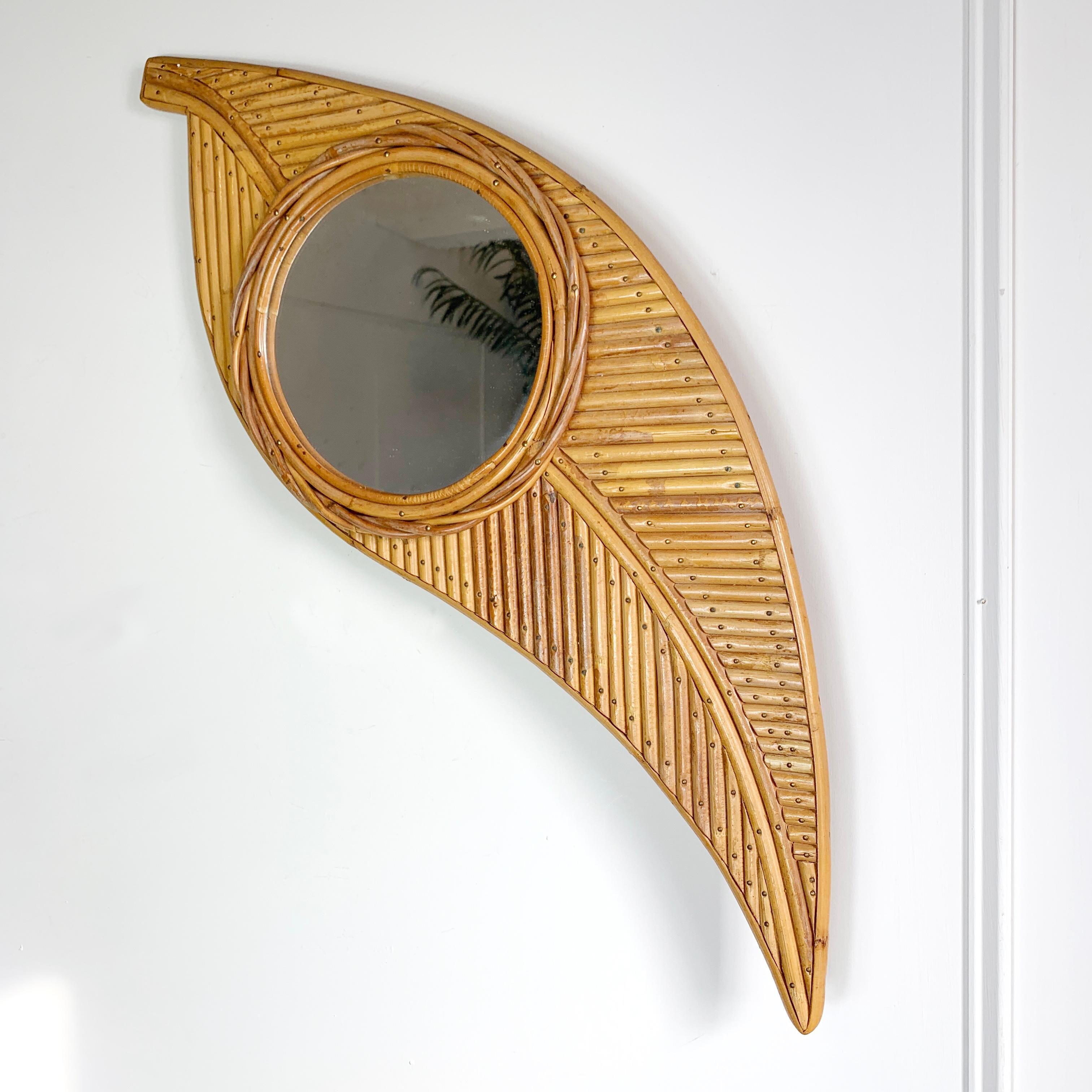 A superb Bamboo mirror, made by the renowned Italian company Vivai Del Sud in the 1970’s, the leaf is made up of layers of individually cut and shaped bamboo strips, all set within a bamboo frame to create the shape of a palm leaf. 

To the centre