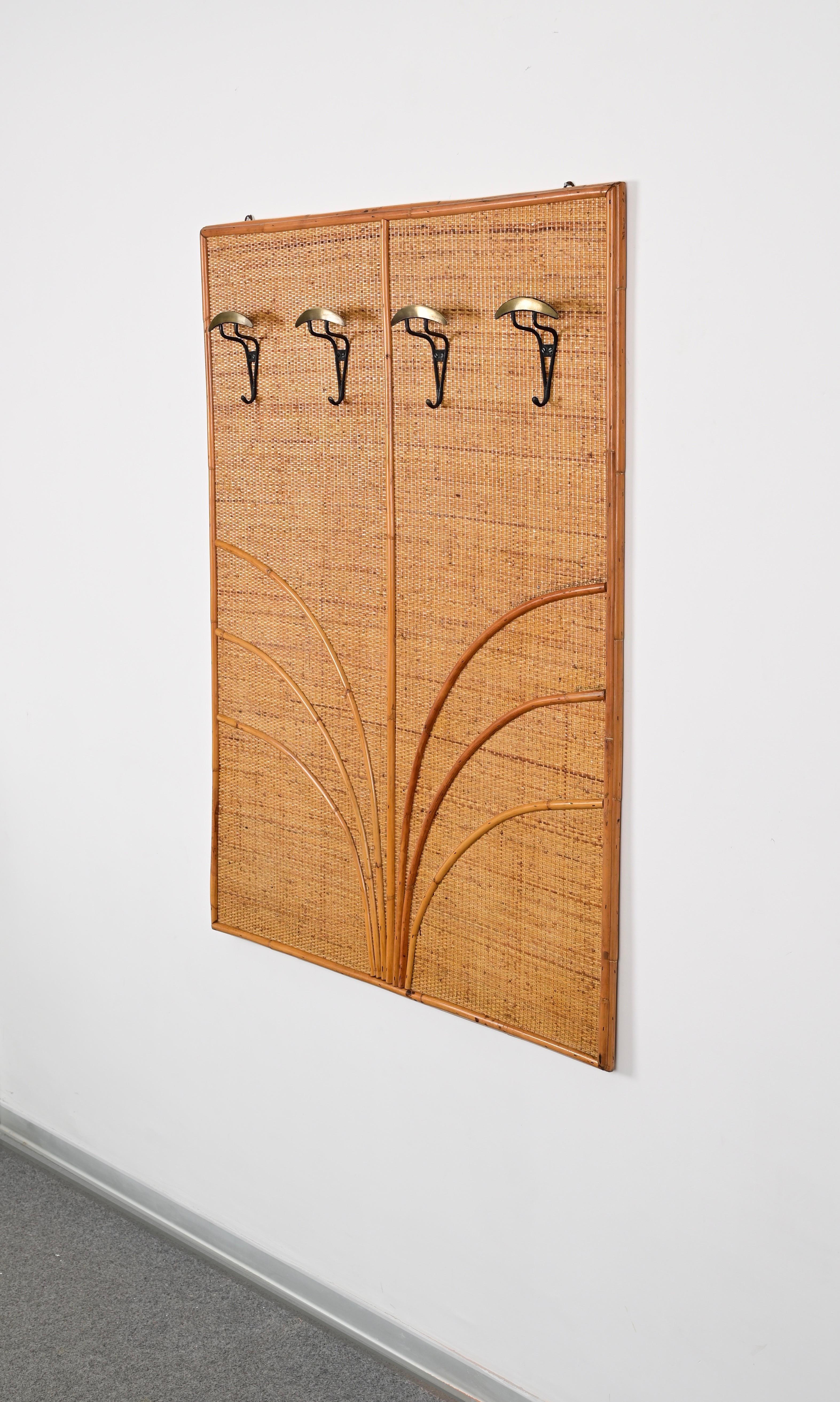 Gorgeous midcentury coat rack in bamboo and woven rattan wicker with solid brass coat hooks. This incredibl elegant piece was made by Vivai del Sud in Italy during the 1970s. 

This iconic French Riviera style coat rack features a rectangular