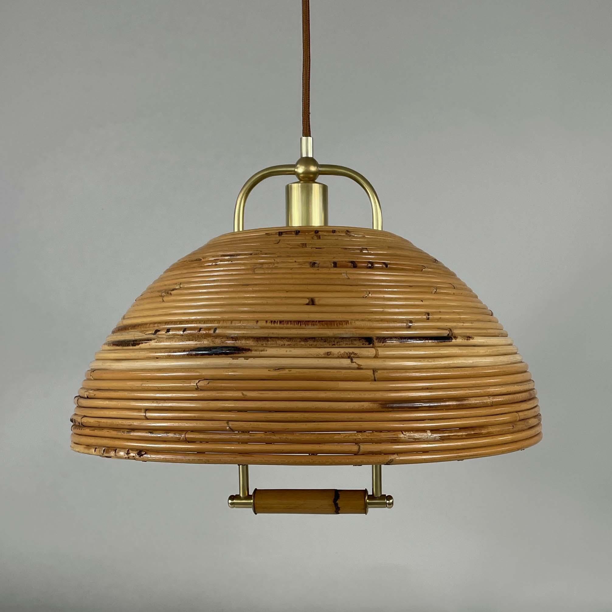 This rattan and bamboo pendant chandelier or suspension light was designed and manufactured in Italy in the 1960s. It features a large dome shaped lampshade with brass hardware. 

The light has been rewired with new fabric cord for use in US and any