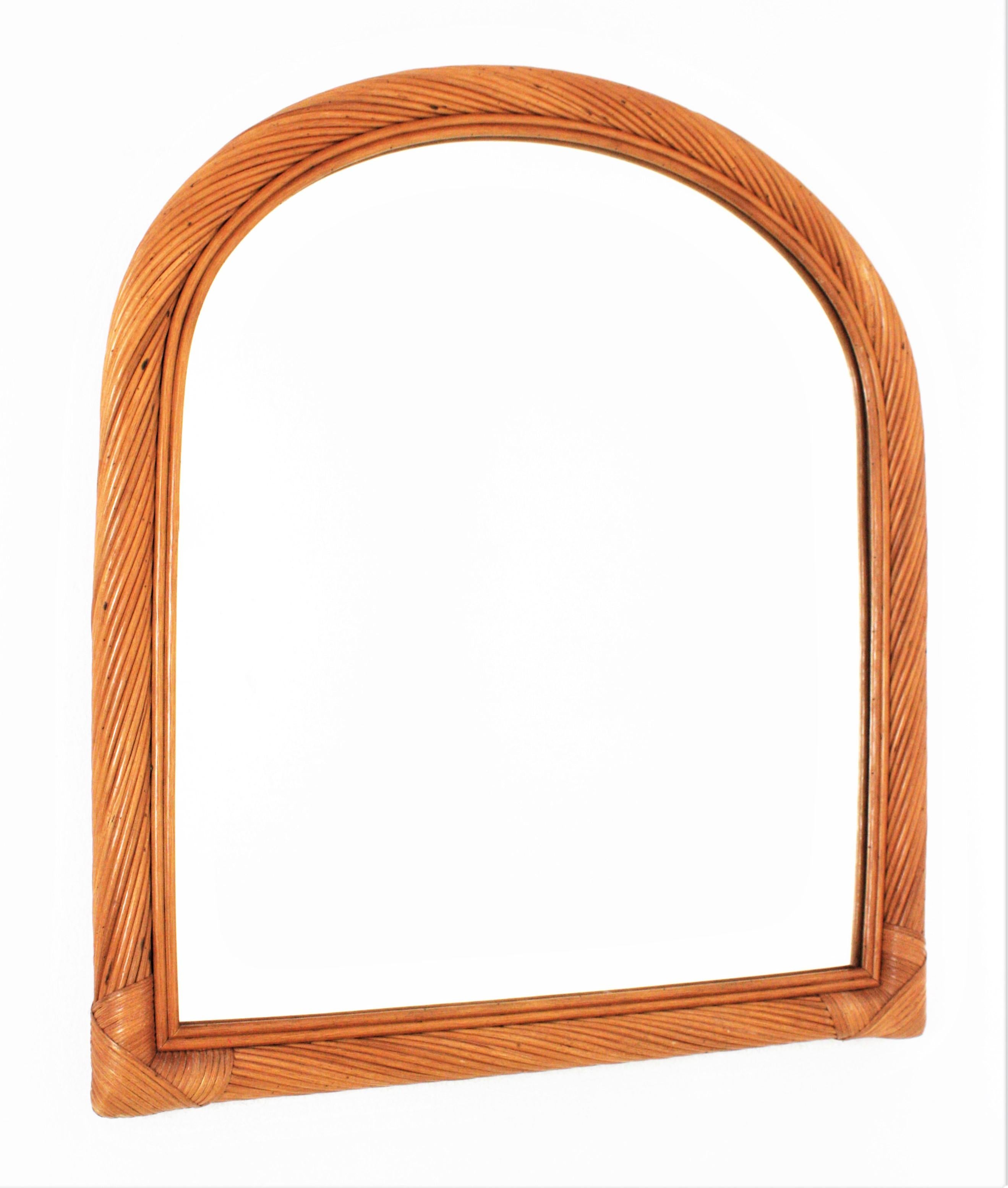 Eye-caching Organic Modern handcrafted in rattan. Attributed to Vivai del Sud. Italy, 1960s.
This mirror features a finely executed frame with arched top made of 20 layers of rattan canes. The layers of rattan are displayed in twisting disposition