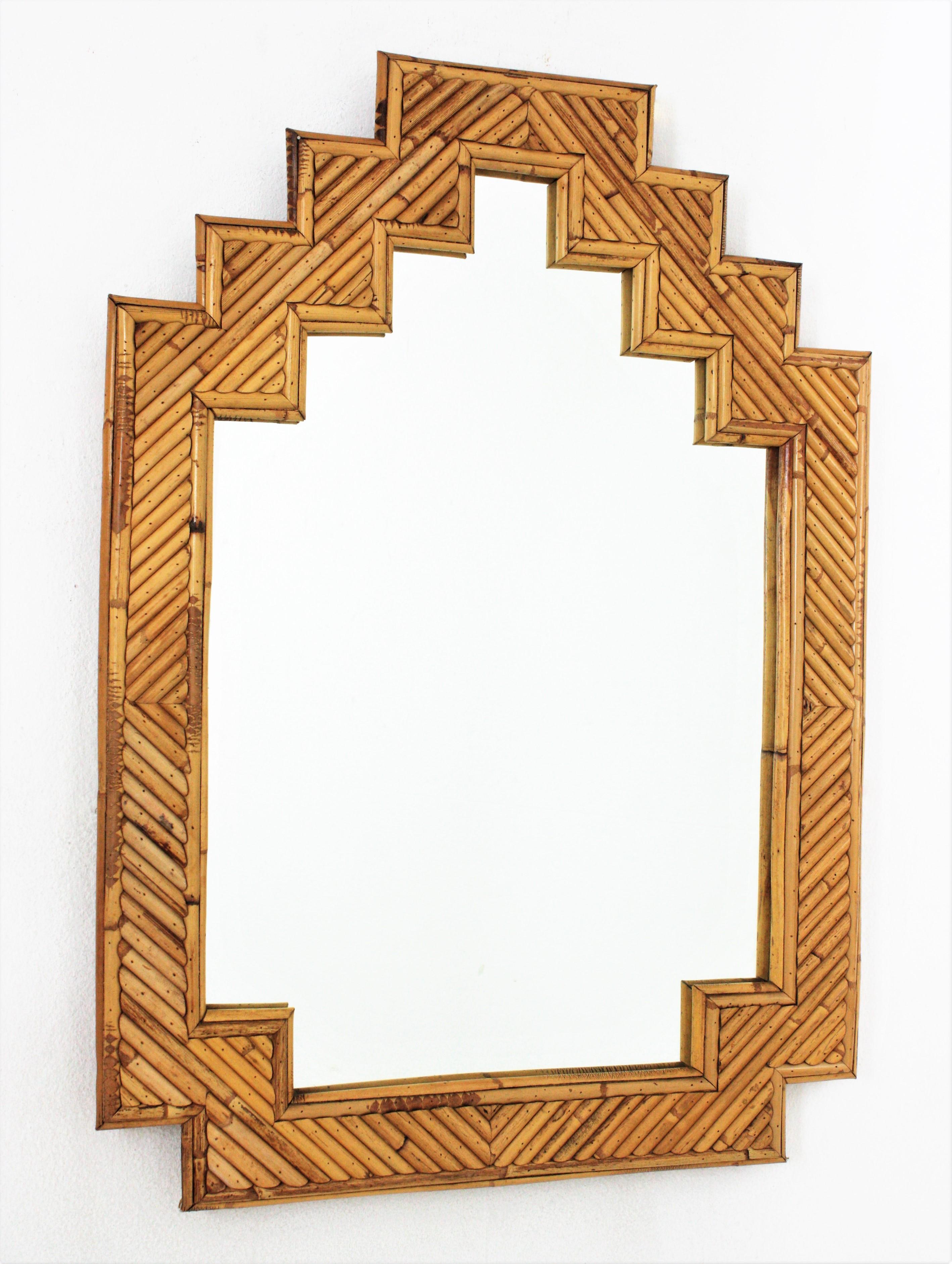 Eye-caching split reed rattan mirror with staggered top. Attributed to Vivai del Sud. Italy, 1960s.
Its design combines Midcentury and Oriental accents.
It will be a nice addition to be used in a bathroom or as wall mirror / console mirror in any
