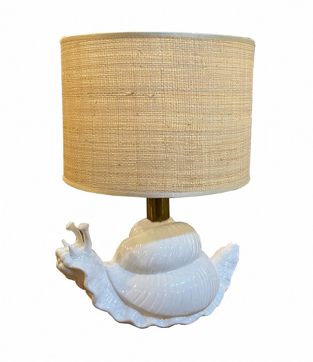 Lámpara de sobremesa de cerámica blanca, cúpula de latón y rafia natural circa 1960. La escultura del caracol tiene una gracia y un encanto de extraordinaria belleza.