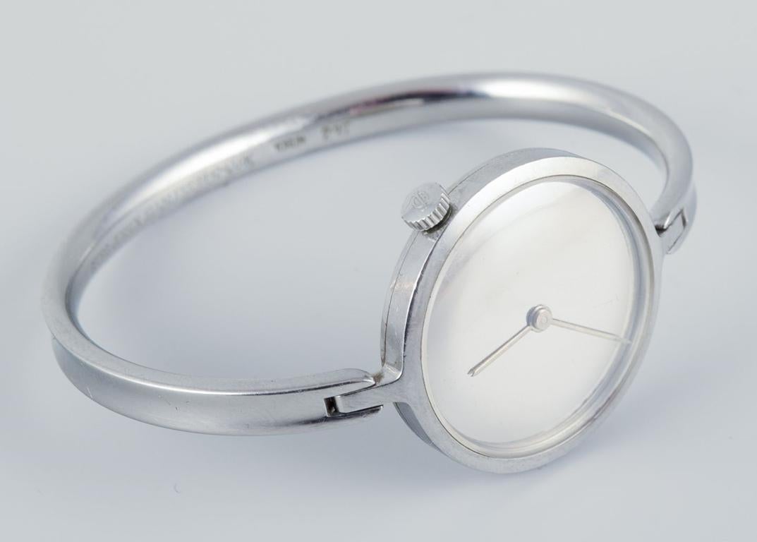 PRE-OWNED GOODS ARE EXEMPT FROM IMPORT TARIFFS FOR U.S., UK, AUSTRALIAN & CANADIAN CUSTOMERS.   
THEREFORE, NO IMPORT TARIFFS WILL BE APPLICABLE TO YOUR PURCHASE. 

Vivianna Torun Bülow-Hübe for Georg Jensen. 
Steel wristwatch. Original box.
Model