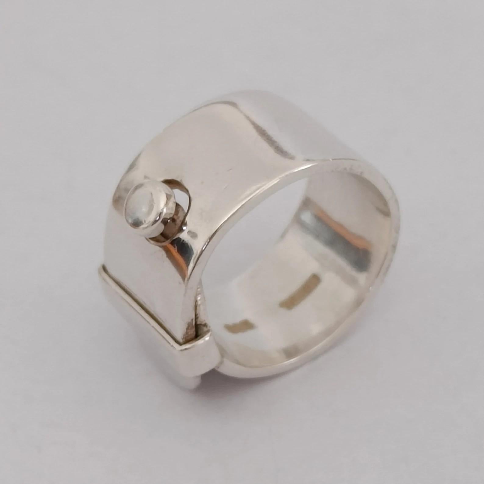 A chunky belt buckle ring in silver designed by Swedish silversmith Vivianna Torun Bülow-Hübe, retailed in 2013.
Stamped TORUN 925

Ring size (approx.) US 7 - FR 54 - UK O
Weight 12.50 grams

Good condition

Original case and certificate