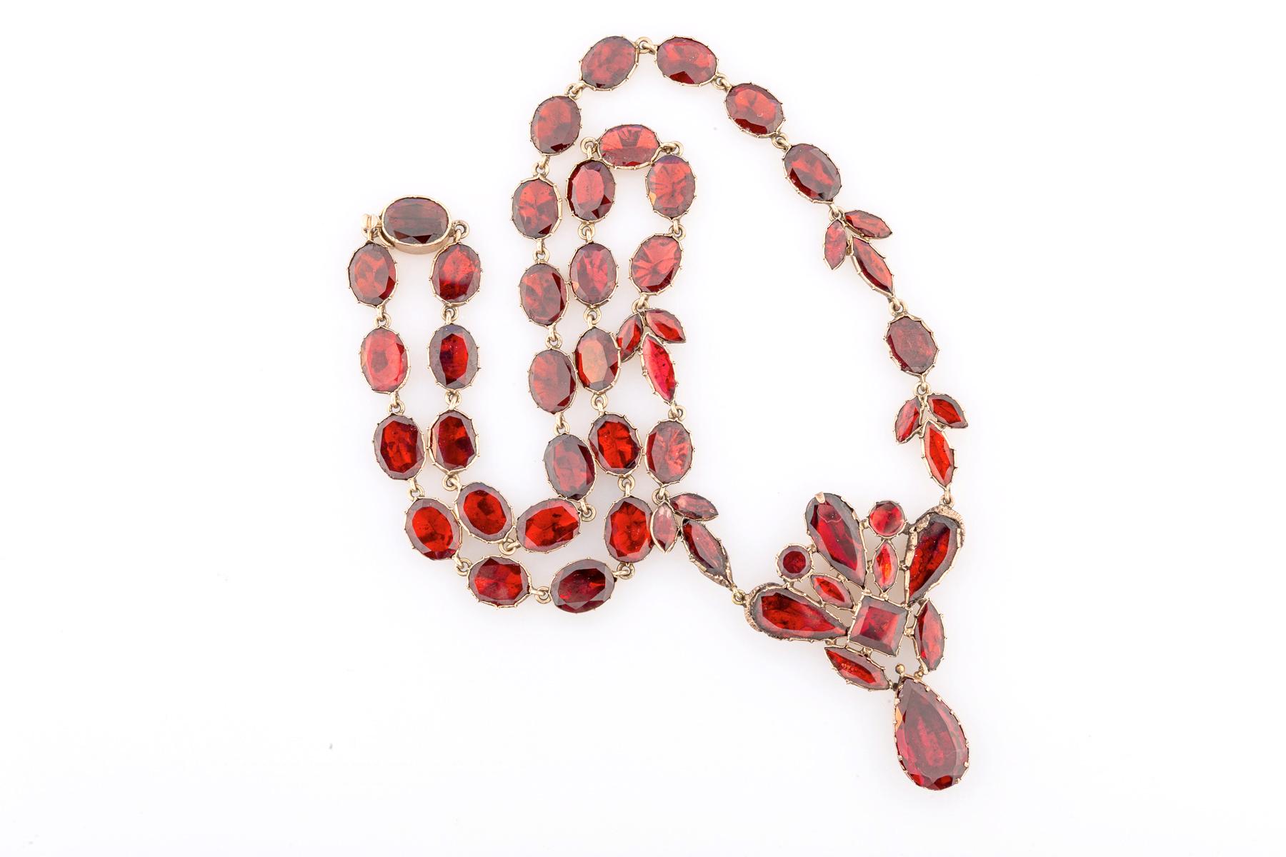 Blooming forms of red Georgian garnets lay smoothly on the neck and fall in an inch arrangement of flowers on the chest. These necklaces have become rare and costly. Red is the color of passion. The reverse is the wonderful Georgian, silky, nine