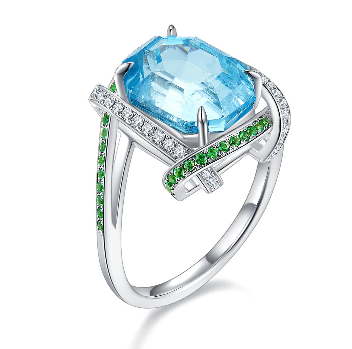 Aquamarine, Tsavorite and Diamond Ring in 18k White Gold. The Octagonal Aquamarine is encircled by 4 lines of pave setting. The Lines of pave is alternating between Tsavorite and Diamond in a ribbon like design. It is giving the ribbon wrapping kind