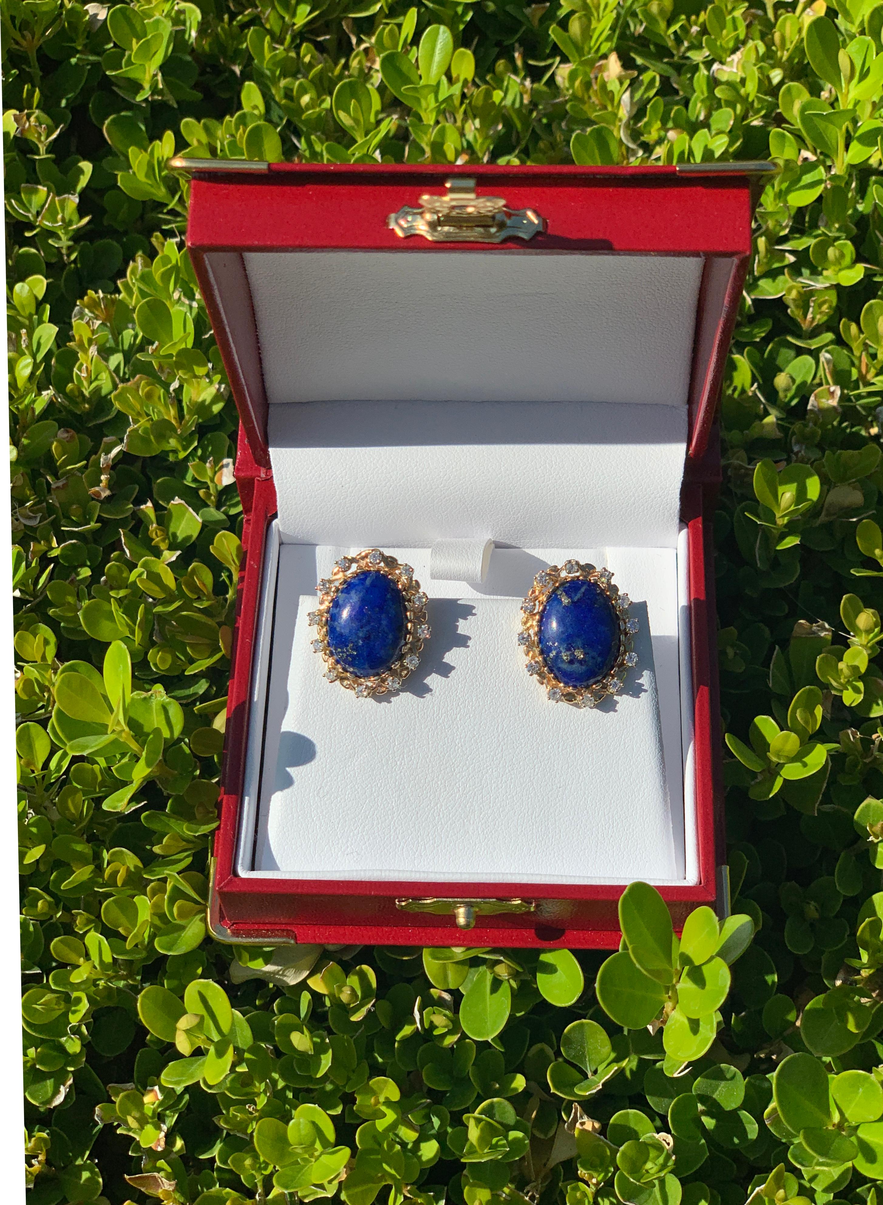 Traditional, classic earrings feature large, vivid blue, oval cut lapis lazuli stones with rich gold flecks, surrounded by sparkling, yellow gold, prong set round brilliant diamond halos in post settings with friction backs for pierced ears. 

2