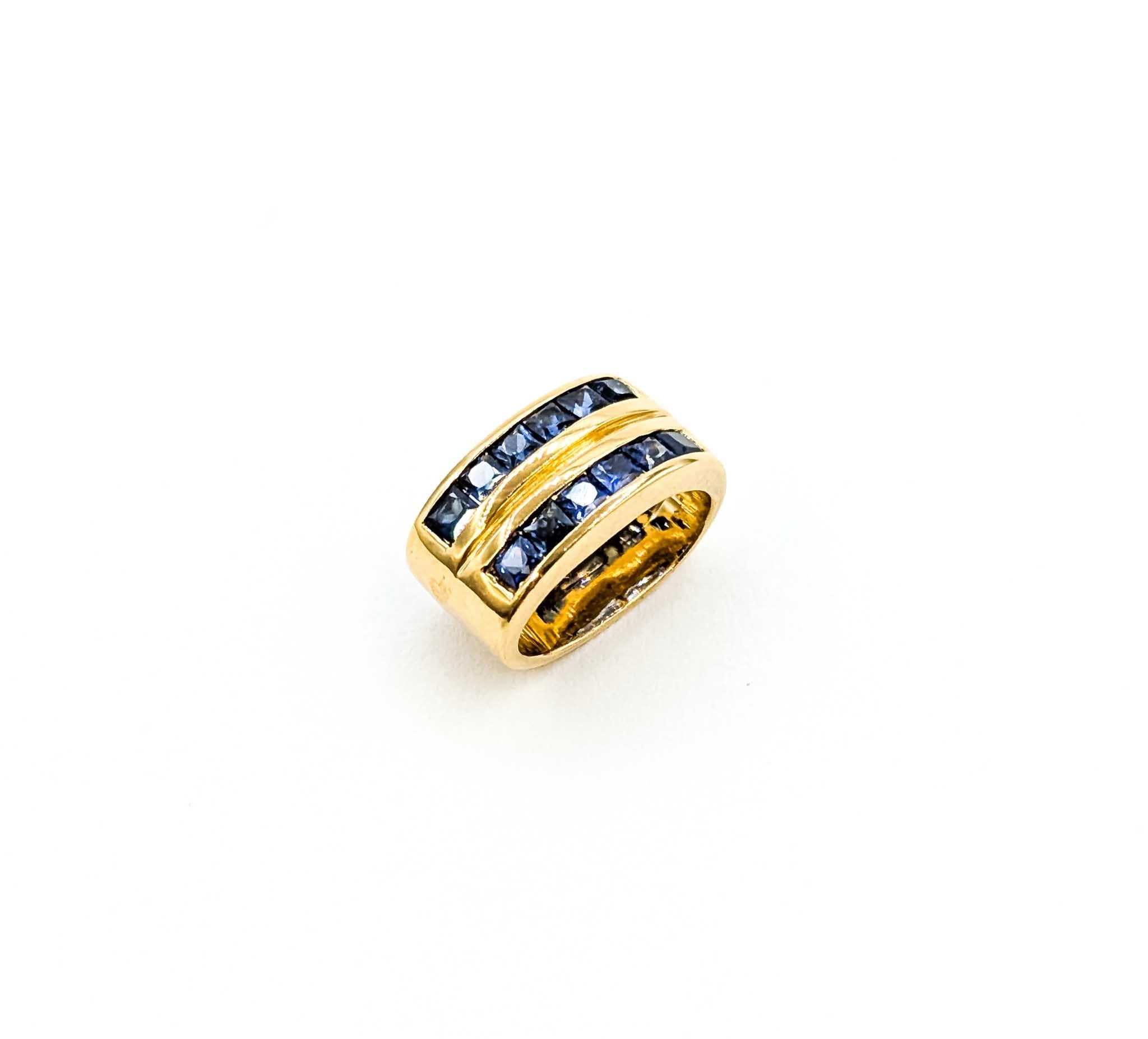 This striking pendant showcases a total of 0.36 carats of square-cut blue sapphires, channel-set in rich 18k yellow gold. The sapphires display a deep, vibrant blue that contrasts beautifully against the warm golden setting. Measuring approximately