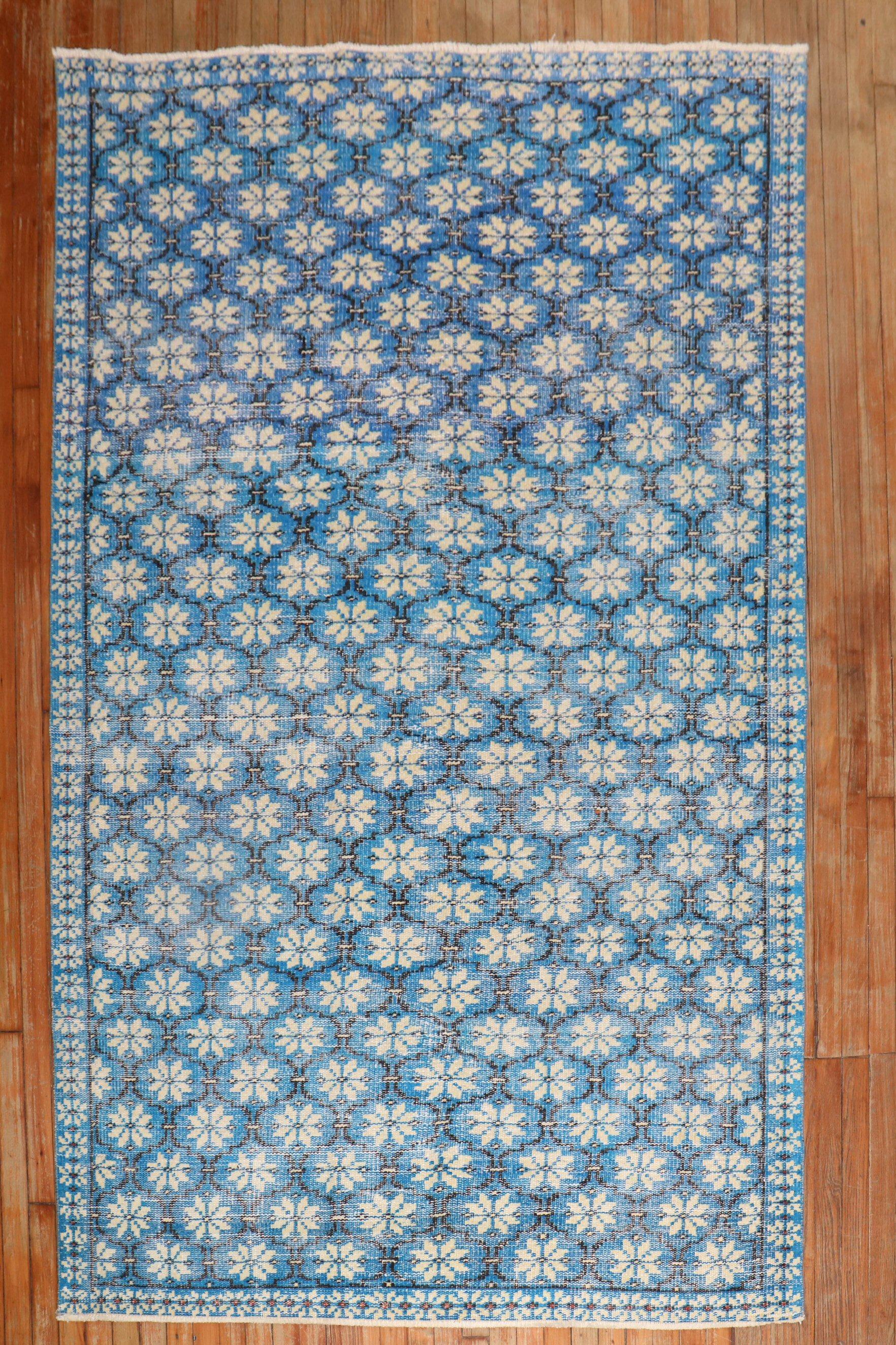 A Mid-20th worn Century Turkish Deco intermediate rug featuring a repetitive all-over design on a vivid blue ground

Measures: 5'3'' x 8'5''.