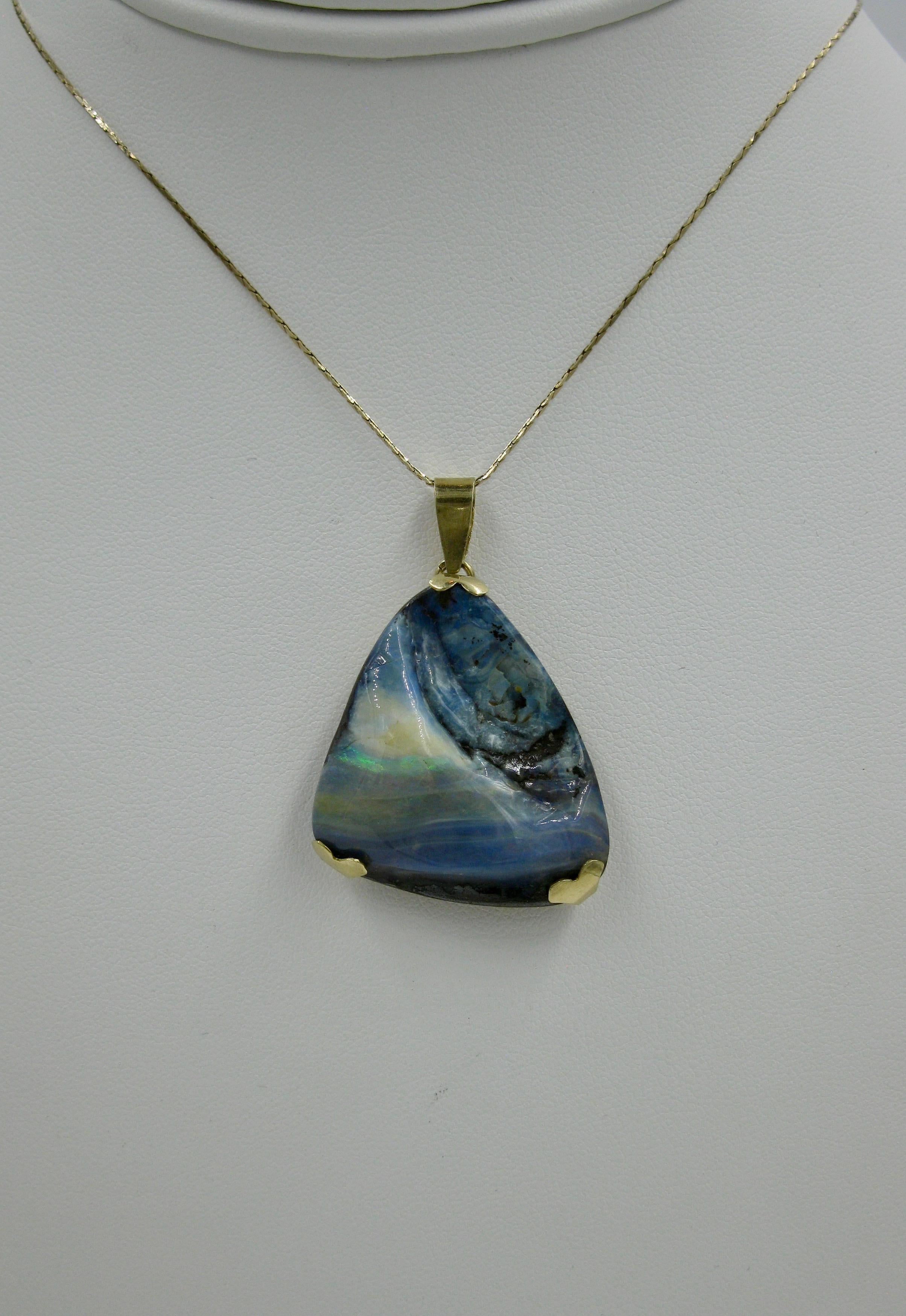 A spectacular Mid-Century Modern Boulder Opal Pendant set in 14 Karat Yellow Gold.  The opal has stunning blue, yellow, white and green colors.  A dramatic and wonderful opal!

The listing is only for the pendant.  The chain is only shown for