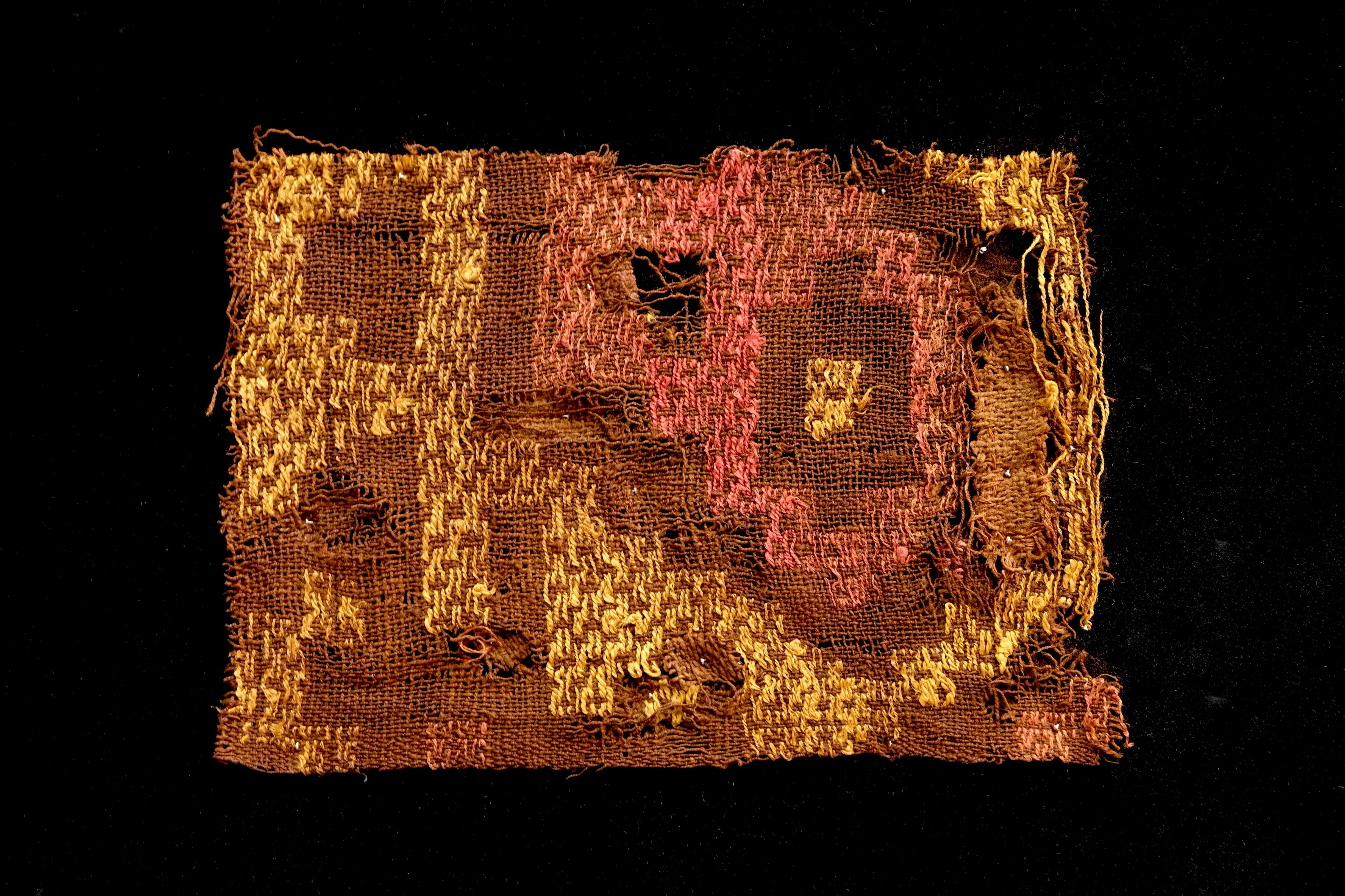 Bright yellow and pink in geometric arrangements adorn this brown pre-Columbian textile fragment.? Framed in a black shadow box.

It is a wonder to behold antiquities such as a pre-Columbian textiles, an authentic piece of art that has been