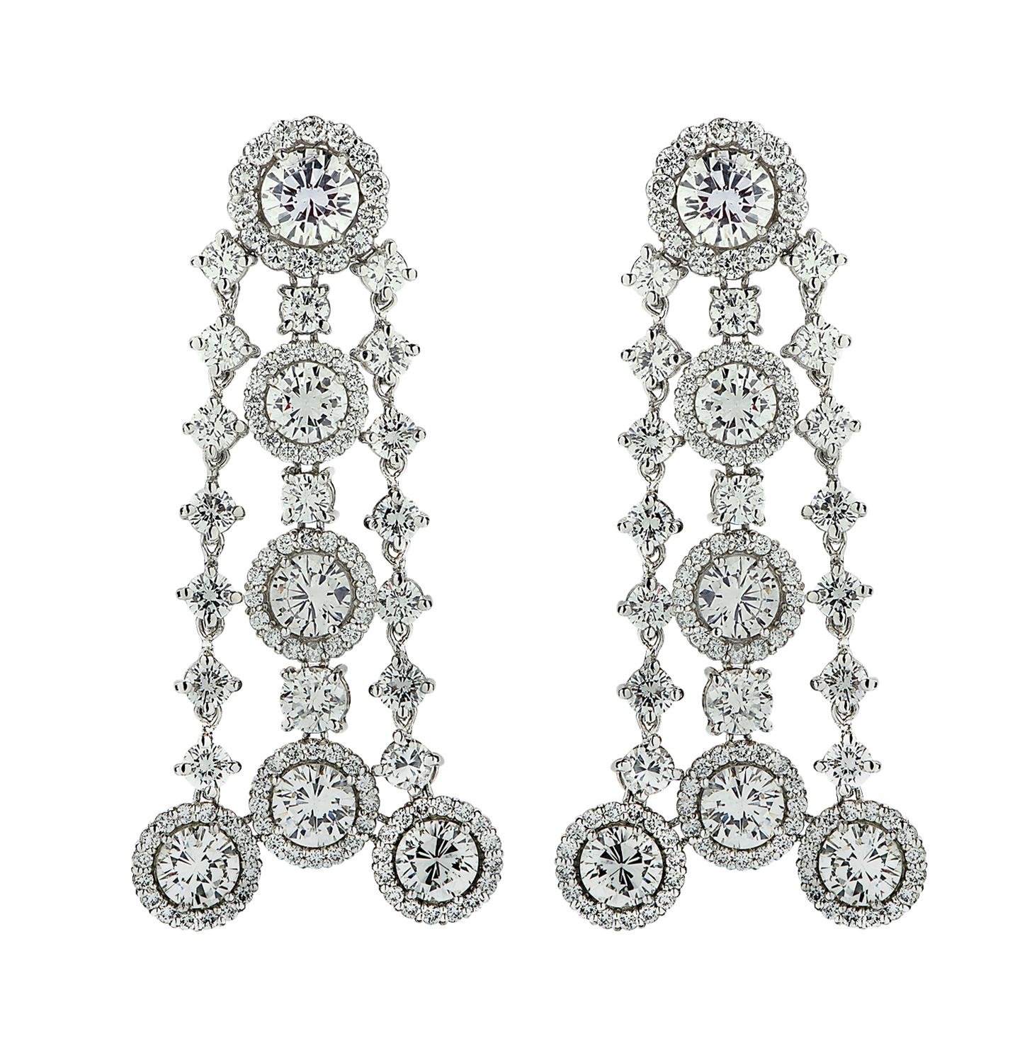From The House of Vivid Diamonds, These striking pair of diamond dangle earrings are crafted in platinum and boast 15 carats of round brilliant cut diamonds, G-H Color, SI1-2 Clarity. The two largest diamonds weigh approximately 2.00 carats, the ten