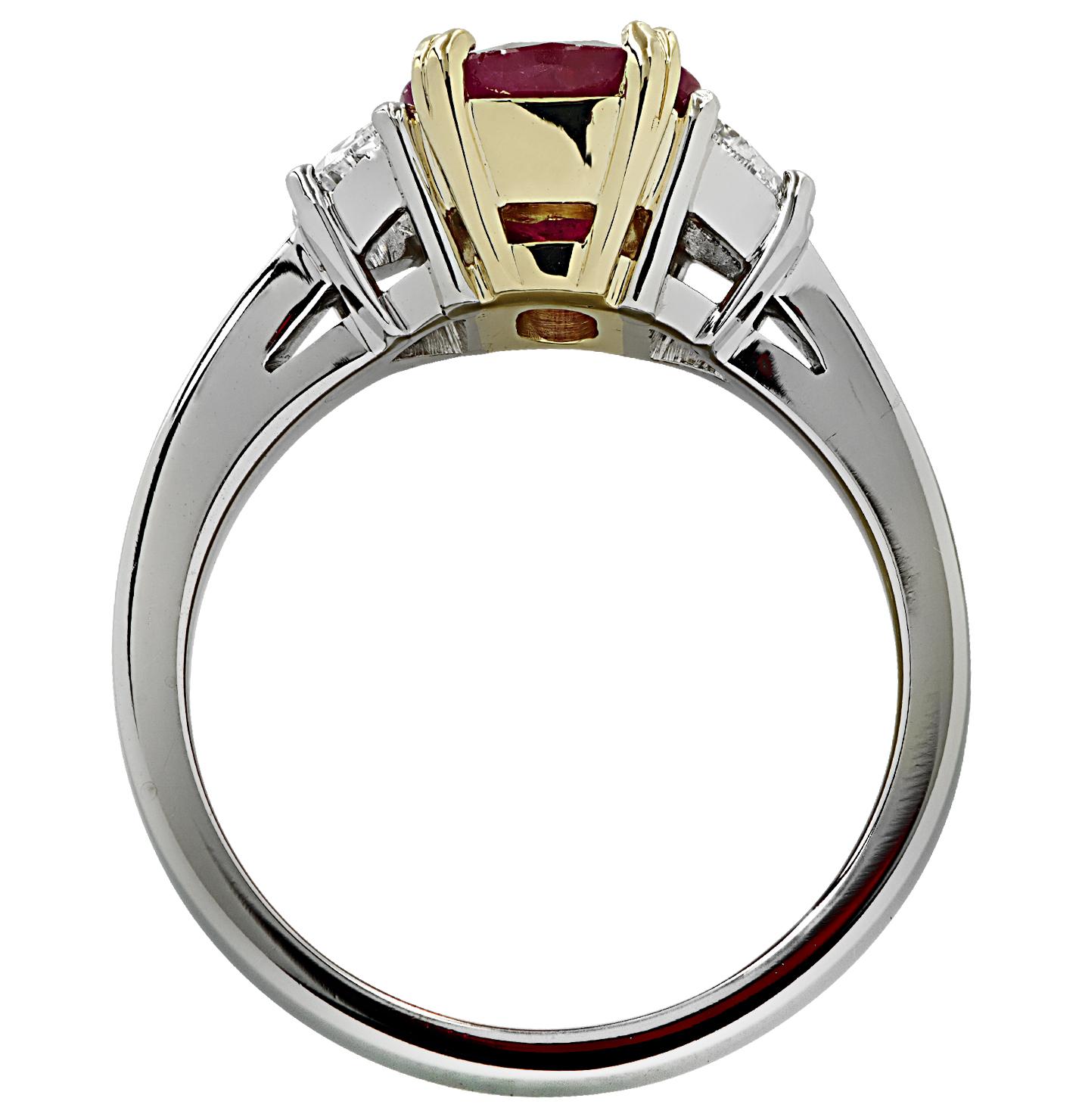 Stunning three stone ring crafted in Platinum and 18 karat yellow gold, featuring a stunning deep red oval ruby weighing approximately 1.8 carats, flanked by two half moon diamonds weighing approximately 0.50 carats total, G color, VS clarity. This