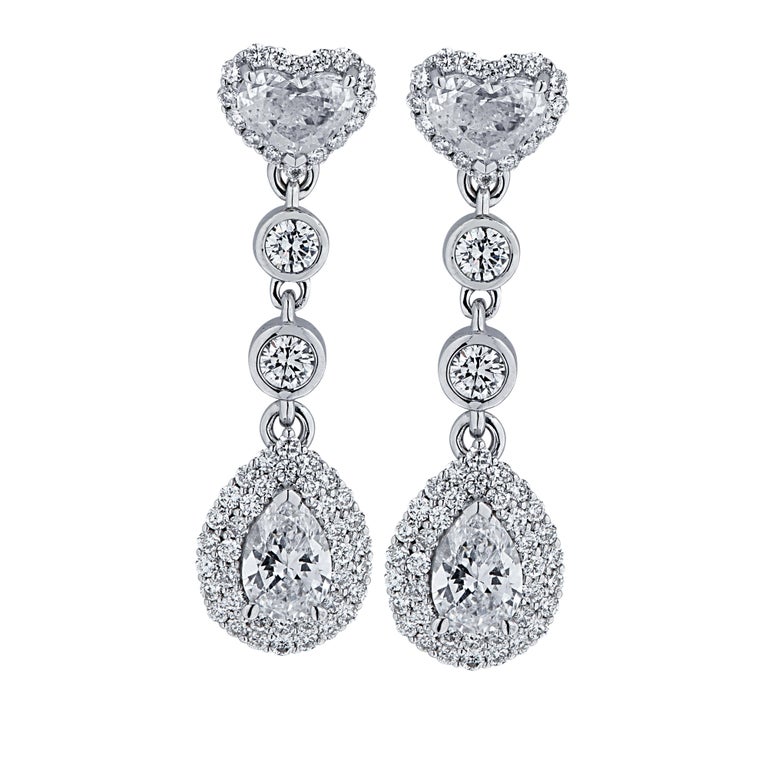 Dazzling Vivid Diamonds diamond dangle earrings crafted in 18 karat white gold featuring 116 heart shape, pear shape and round brilliant cut diamonds weighing 1.88 carats total, G color, VS1 clarity. Each gorgeous earring showcases a pear shape