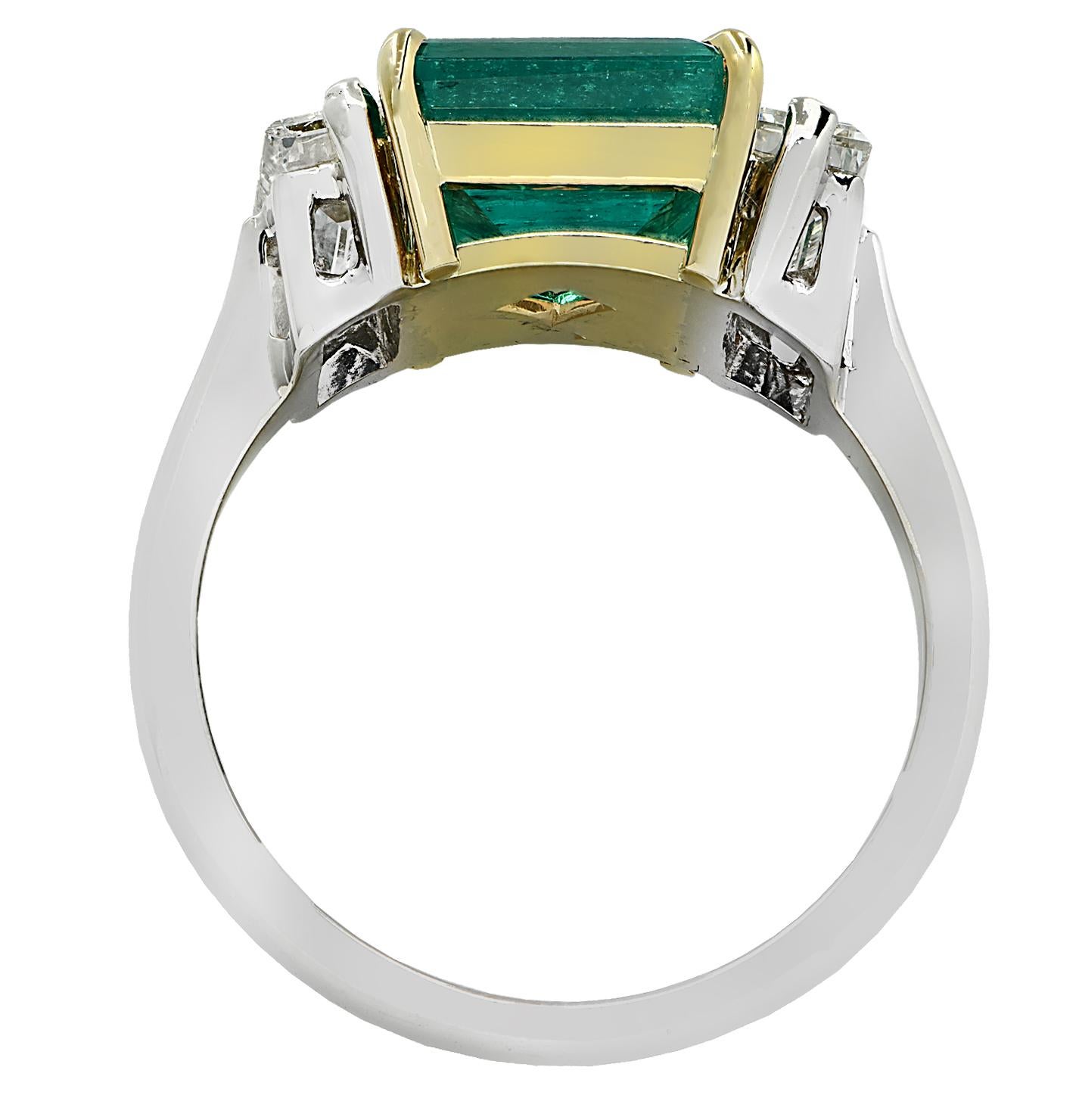 A spectacular creation from the house of Vivid Diamonds, this ring is crafted by hand in 18 karat yellow and white gold showcasing an AGL certified, bright green emerald weighing 2.67 carats total with modern minor treatment. The emerald is an