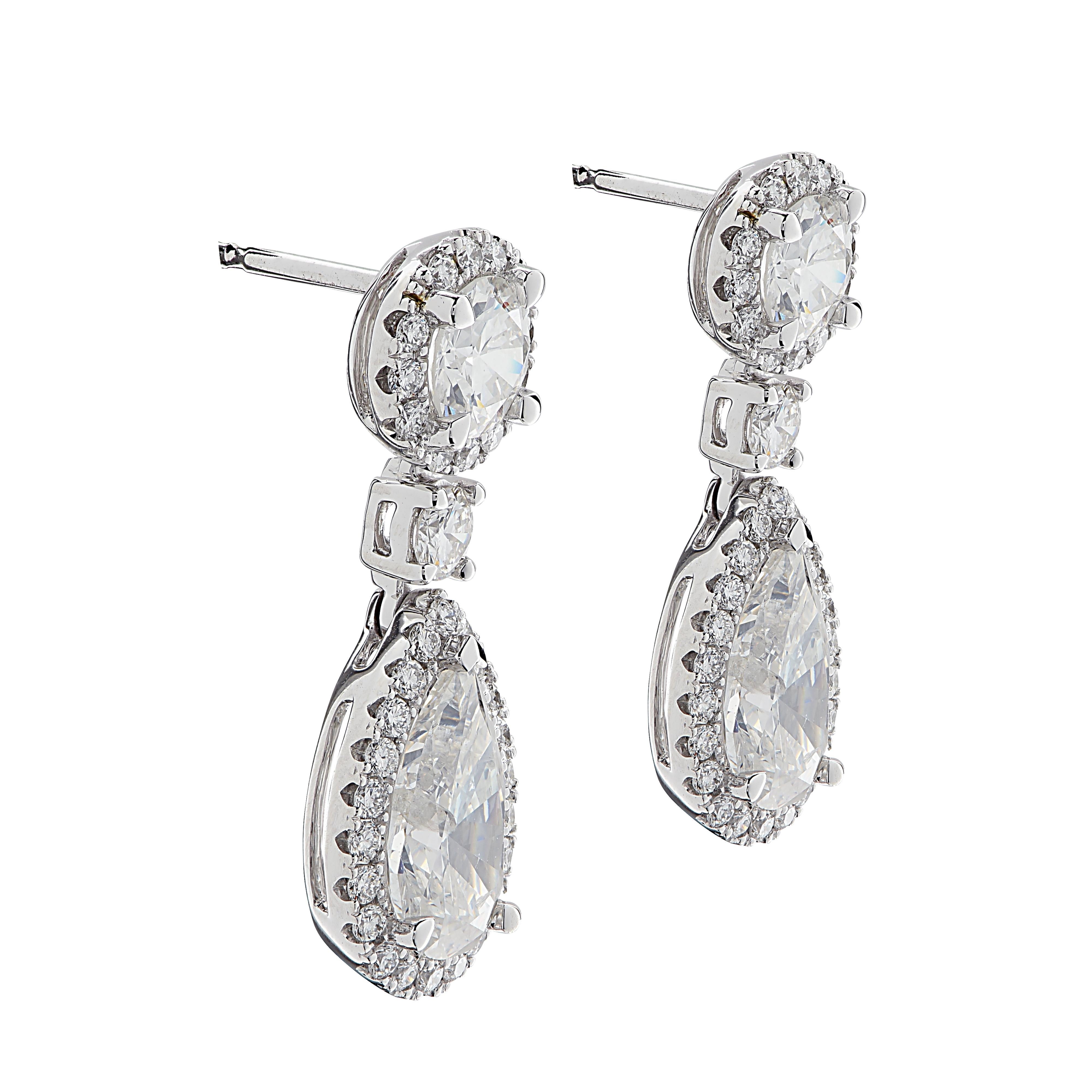 Dazzling Vivid Diamonds dangle earrings crafted in 18 karat white gold showcasing 2 pear shaped diamonds weighing 2.25 carats total, H-I color, SI2- I1 clarity, 2 round brilliant cut diamonds weighing .77 carats total, H-I color, SI2 - I1 clarity