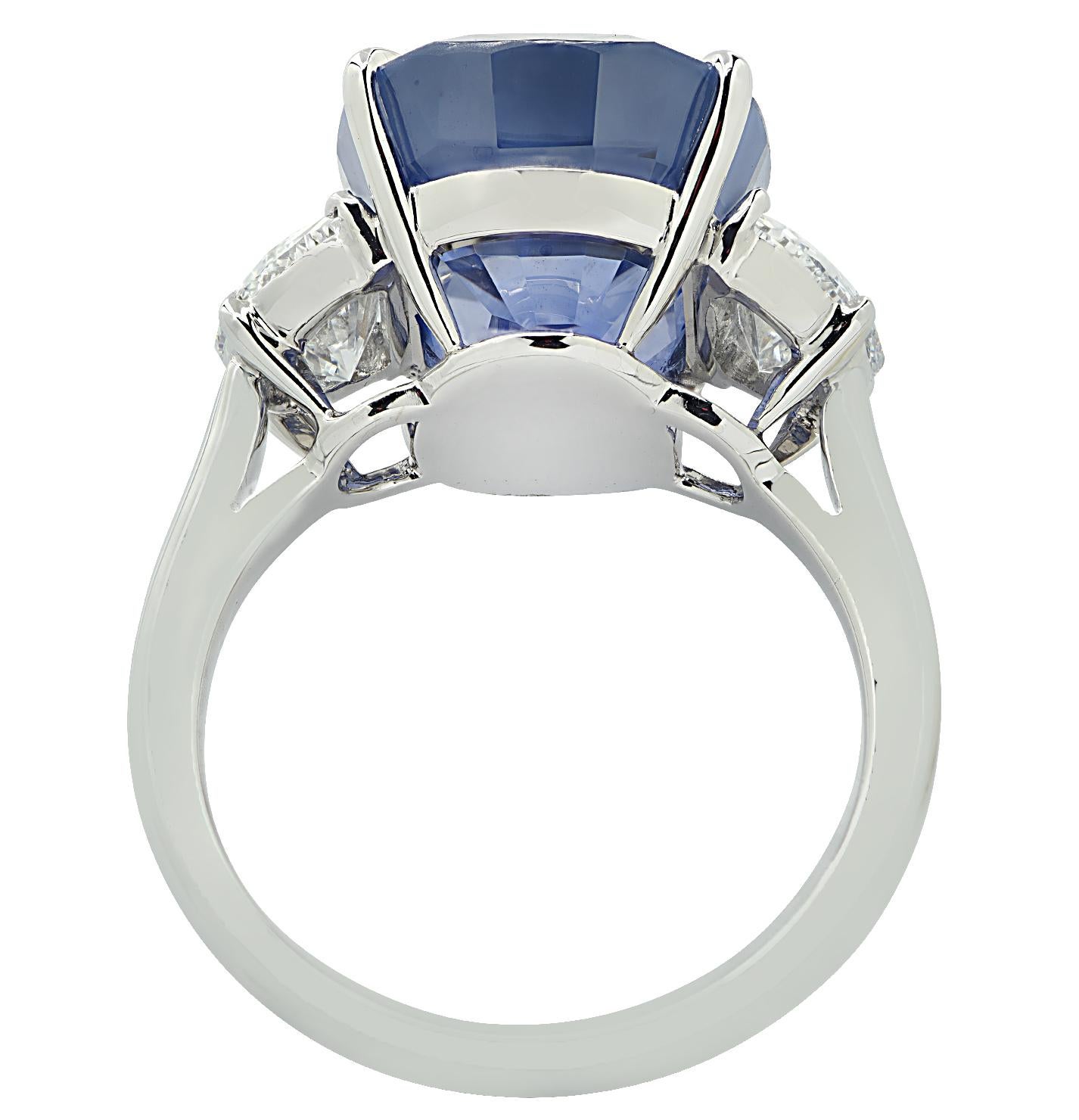 Sensational Vivid Diamonds three stone ring finely crafted by hand in platinum, featuring an exceptional AGL certified Ceylon no heat oval cut blue sapphire weighing 12.80 carat accompanied by two half moon diamonds weighing approximately 1.34