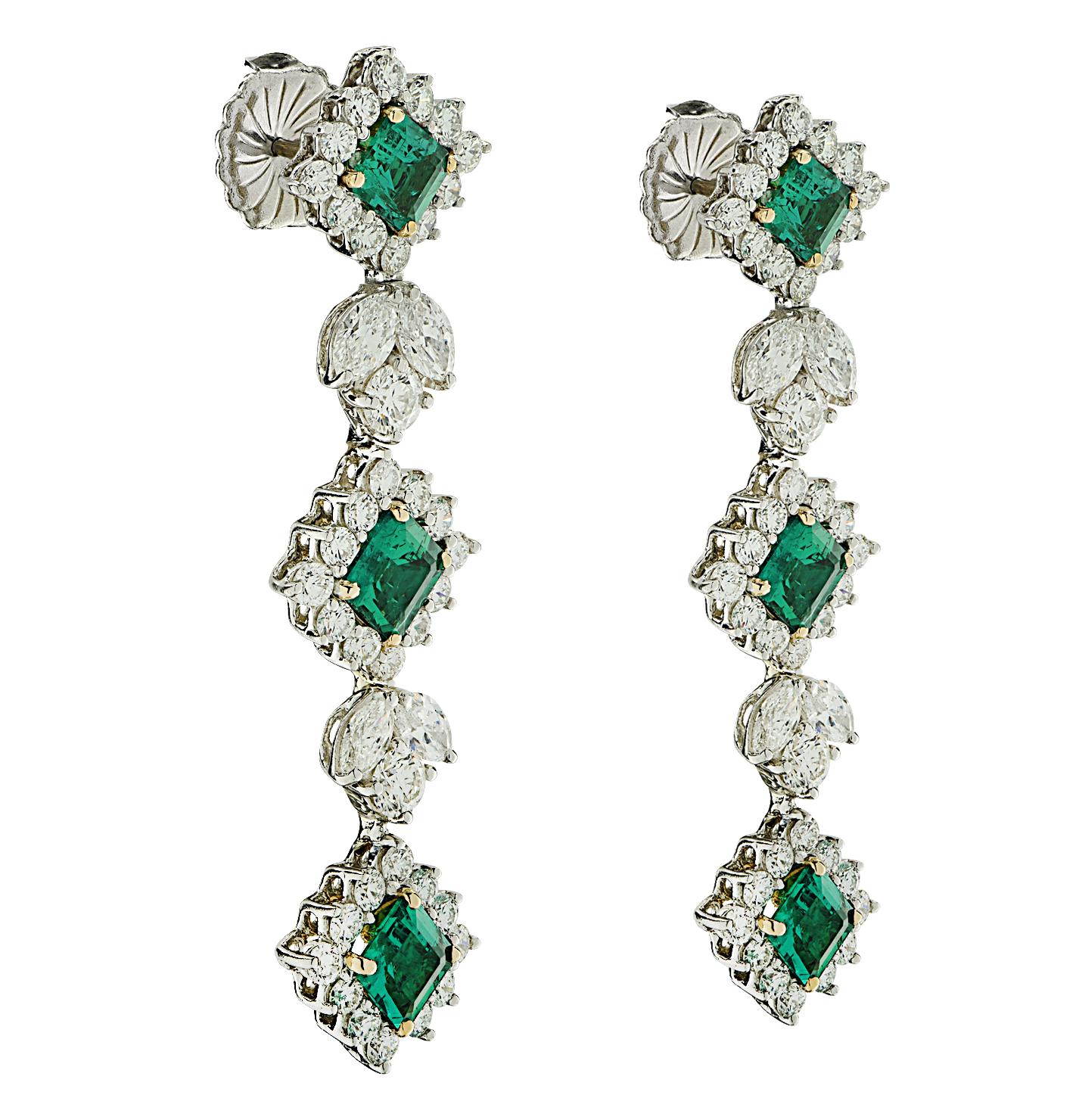 Spectacular Emerald and Diamond dangle earrings crafted in Platinum and 18 karat yellow gold, showcasing 6 square emerald cut green emeralds weighing approximately 3.93 carats total, and 82 mixed round brilliant cut and marquise cut diamonds