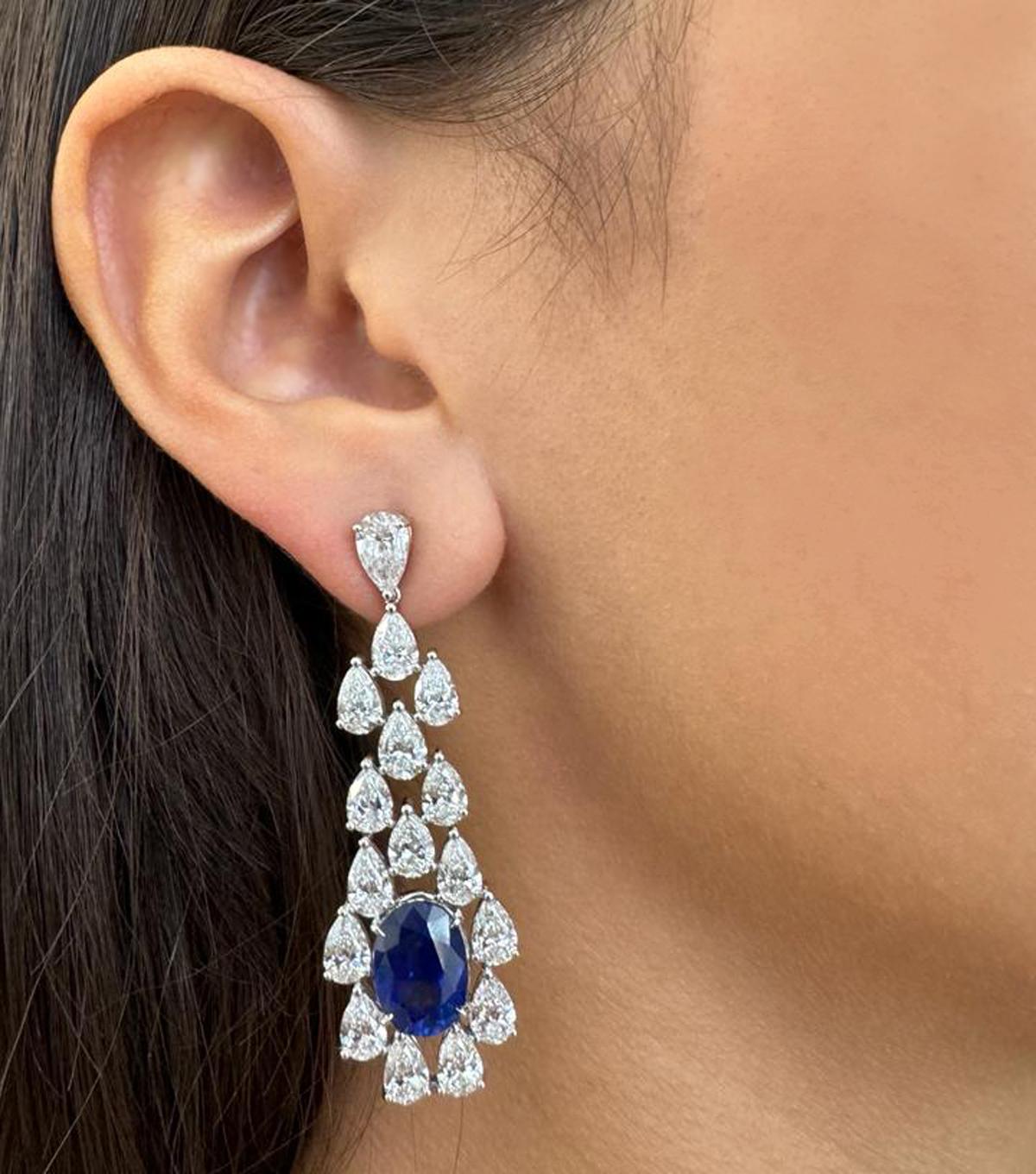 From the house of Vivid Diamonds, These resplendent earrings have been meticulously fashioned from 18k white gold and showcase a pair of regal, GIA-certified Ceylon sapphires, radiating a deep royal blue hue and weighing an impressive 10.93 carats