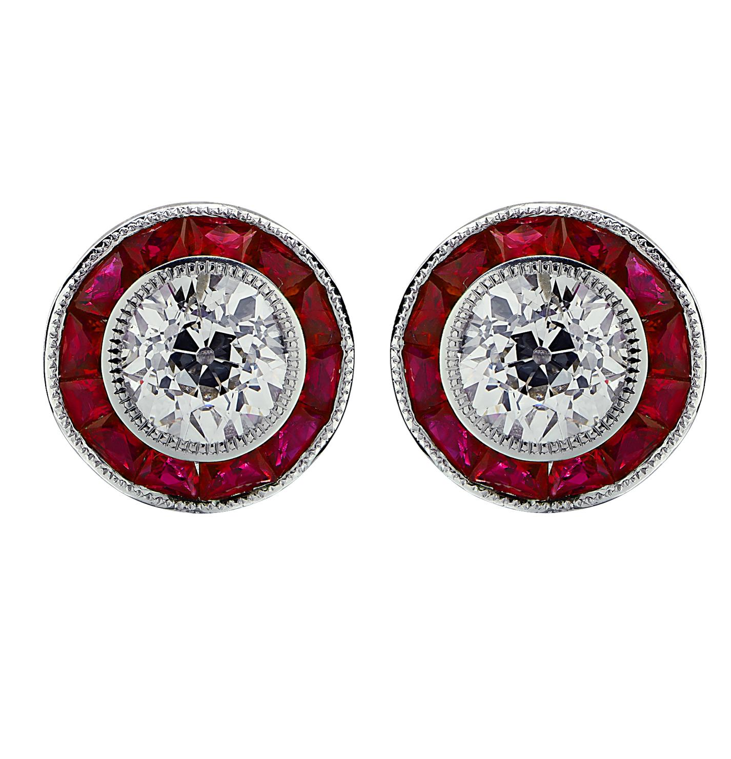 Enchanting Vivid Diamonds Stud earrings crafted in Platinum featuring 2 GIA certified European cut diamonds, weighing 2.09 carats total, J color, VS2-I1 clarity accented by 24 French cut rubies, weighing approximately 5.80 carats total. The European