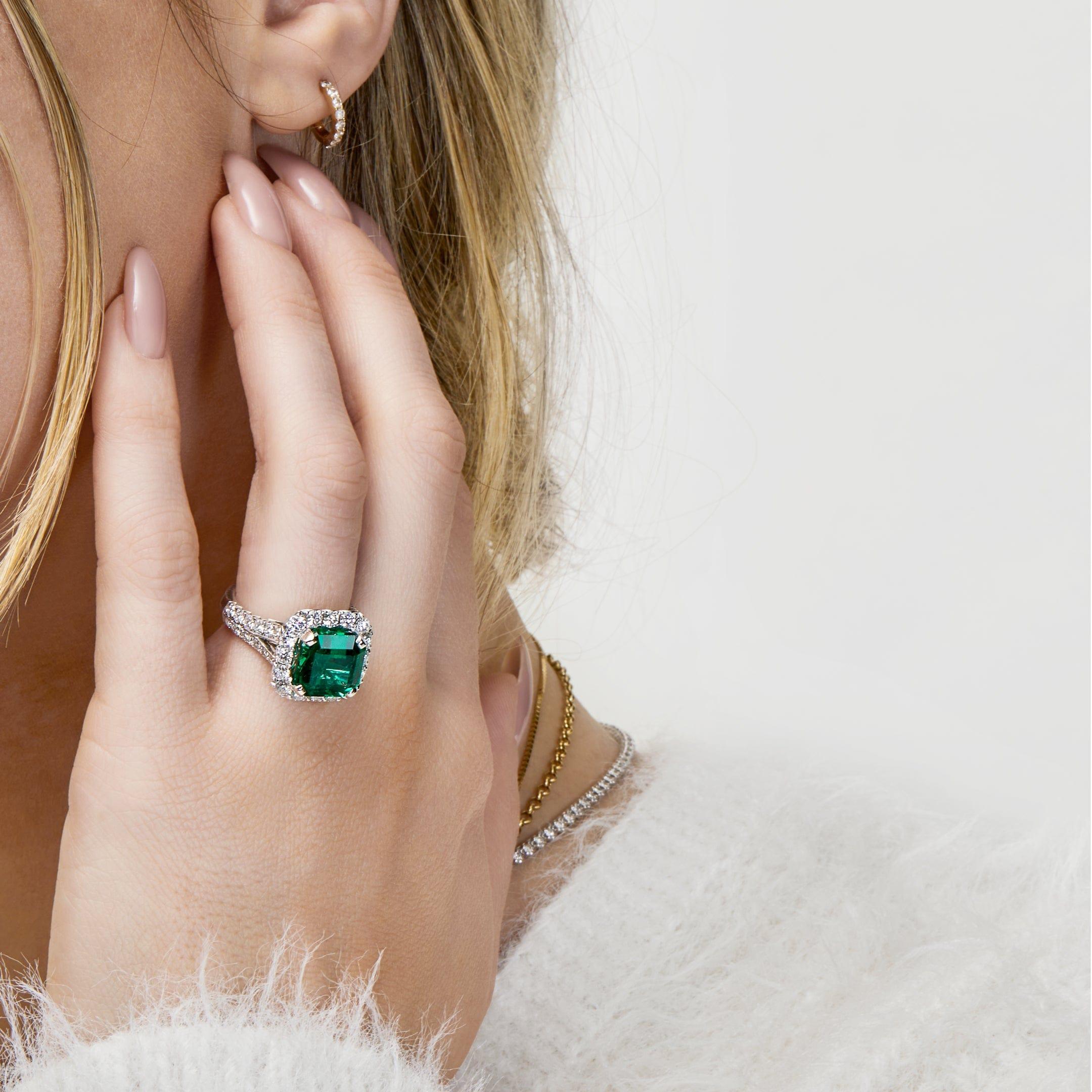 We invite you to take a closer look at this Zambian emerald ring featuring a 5.84ct vivid green emerald that has been cut into an octagonal step-cut adorned with 1.65ct diamonds. Set upon an 18-karat white gold band, contrasting with the emerald's