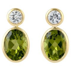 Vivid Green Oval Shaped Peridot Dangle Earrings With White Sapphire In 18k Gold