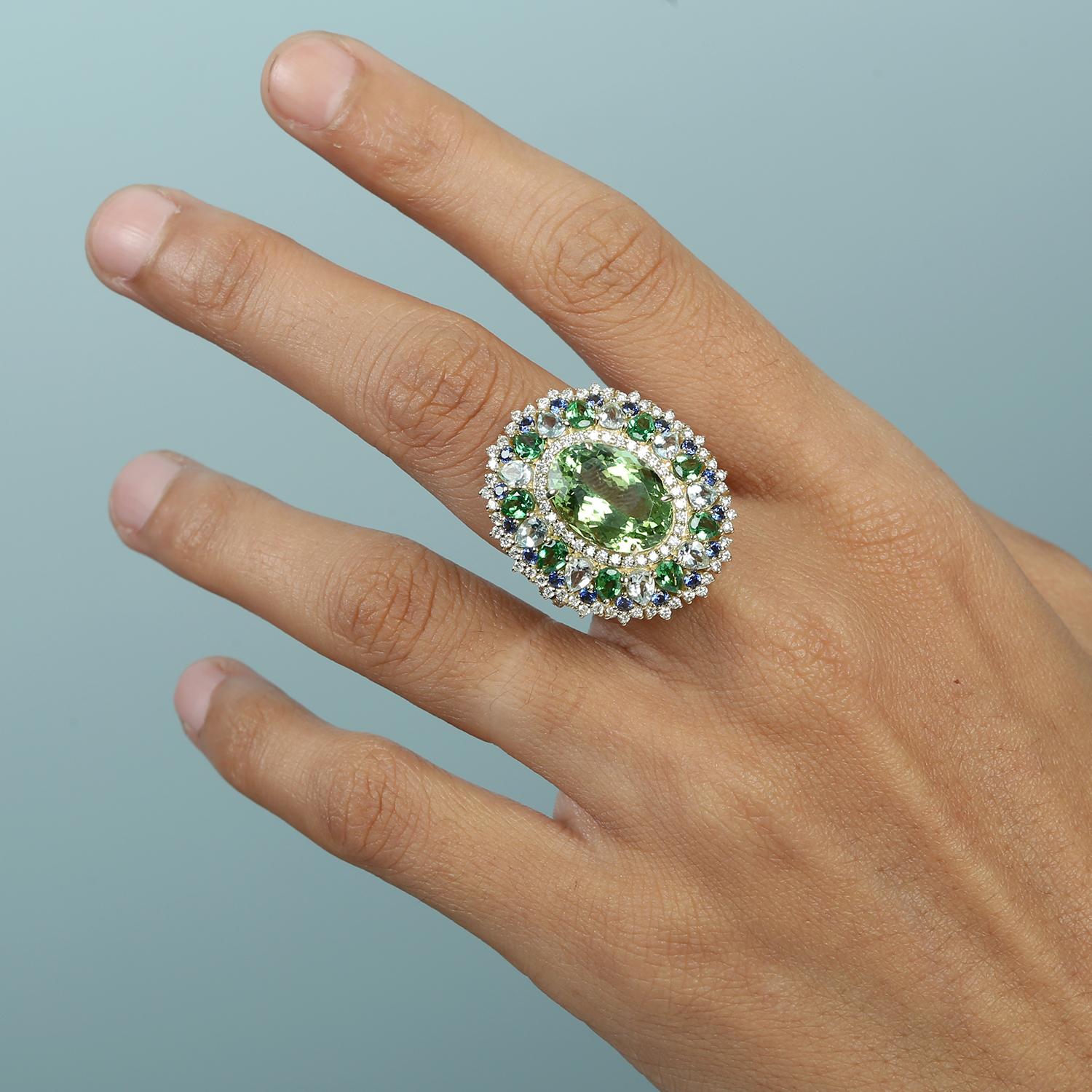 Questo straordinario anello cocktail è una vibrante vetrina di colore e brillantezza, con un mix armonioso di acquamarina, zaffiro, tormalina e tsavorite. Incastonato in oro giallo 14k lucido e impreziosito da diamanti scintillanti, è una