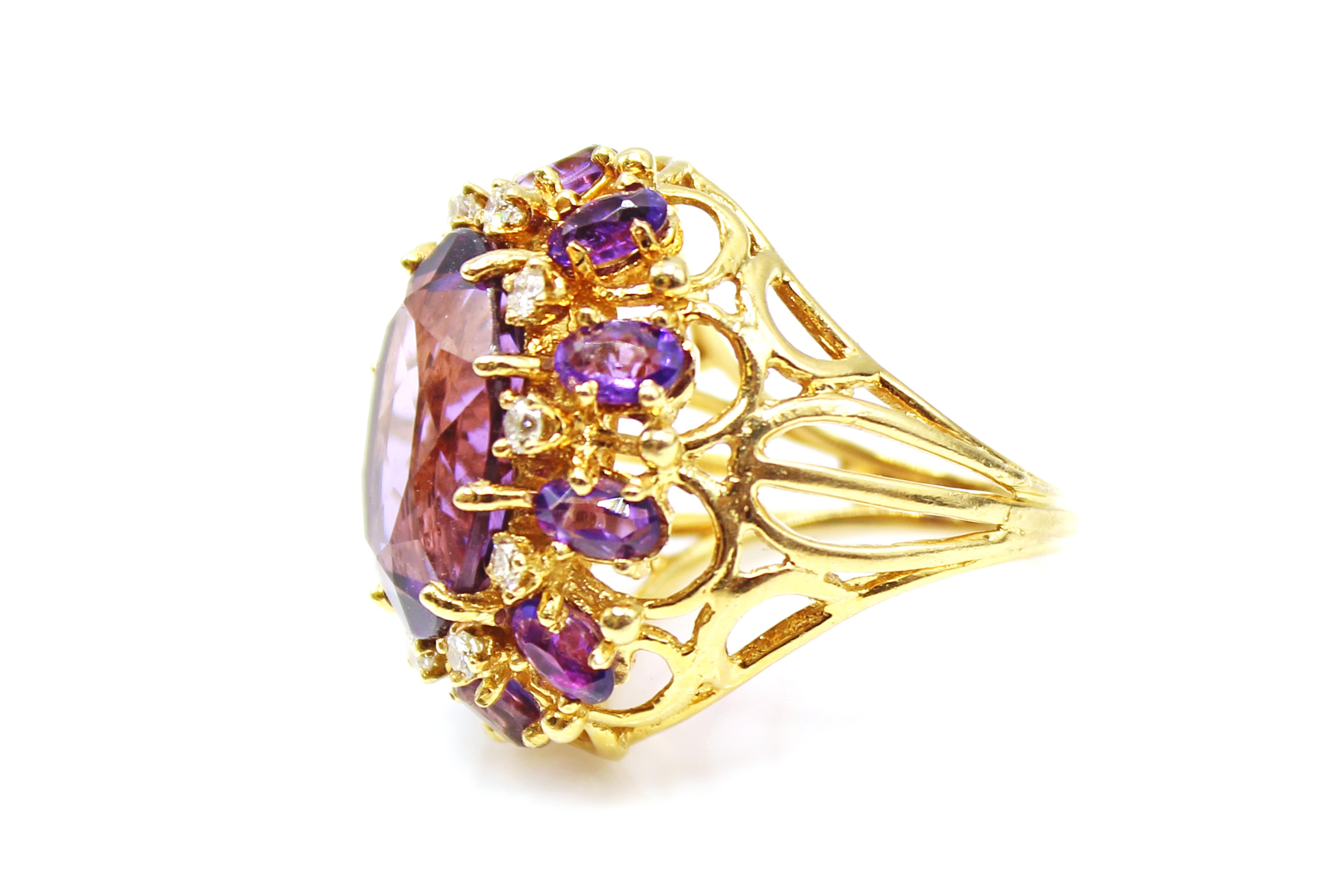 This stunning vivid purple amethyst is cut as a faceted oval, giving it an amazing sparkle, life and fire. Set in a masterfully hand-crafted yellow gold mounting, the 10 bright white sparking diamonds and 10 smaller oval amethysts surrounding the