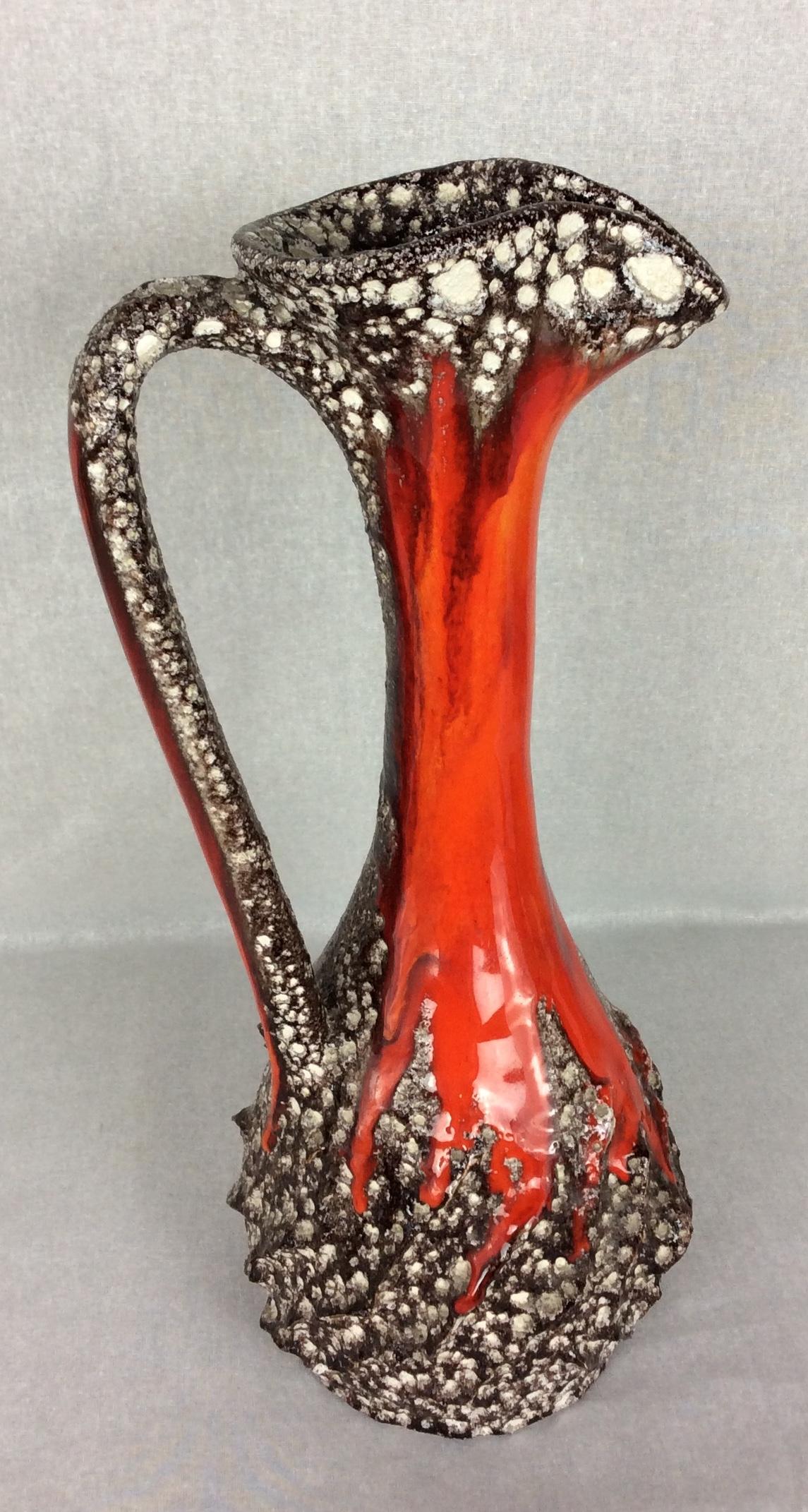 This large dazzling mid-century glazed ceramic pitcher vase was designed and crafted by Charles Cart.  This well-known listed ceramic artist called it Cyclope because of the large volcanic dimples created during the firing of the pottery which