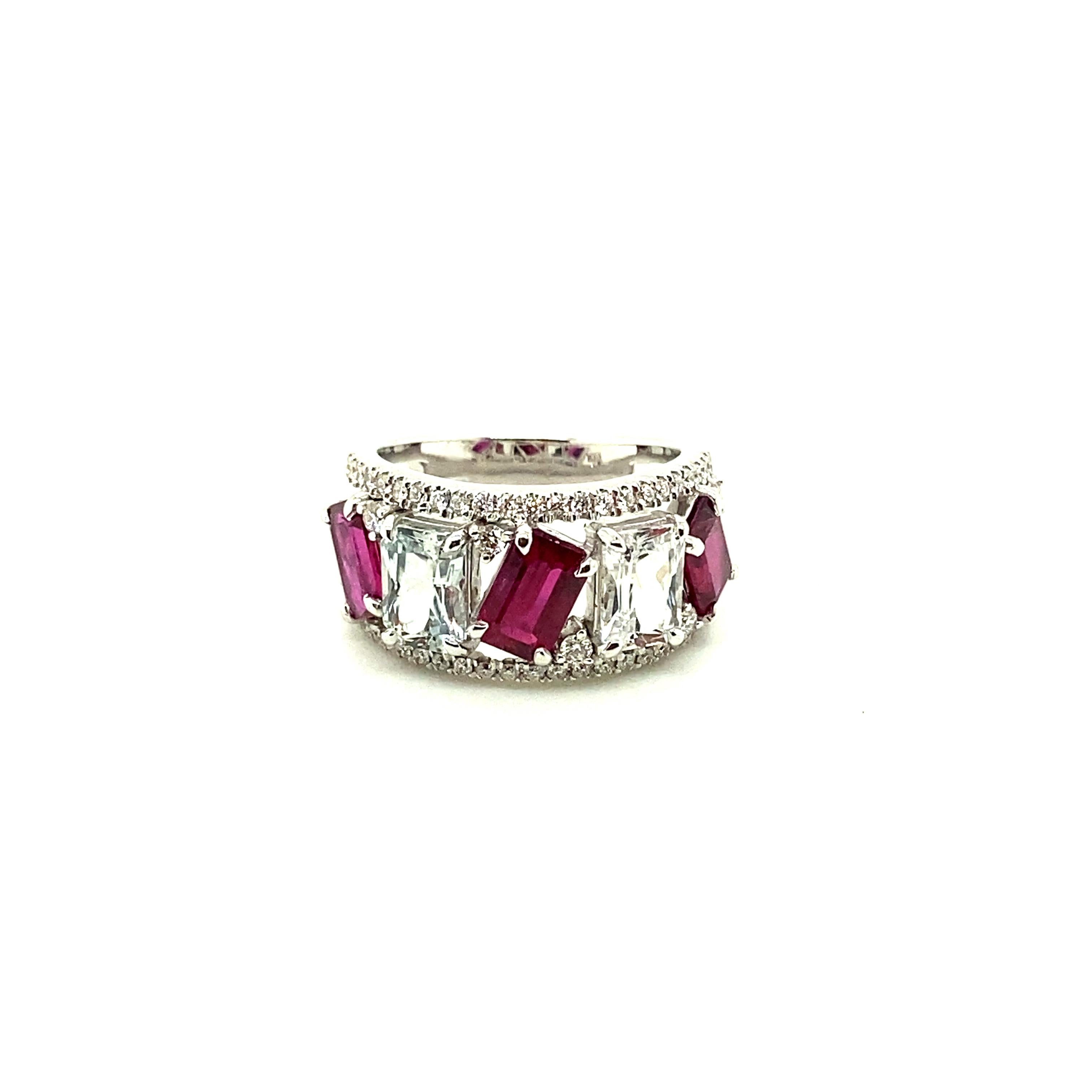 Vivid Red Ruby and White Sapphire Diamond Gold Ring:

A beautiful ring, it features three emerald-cut vivid red rubies weighing 2.45 carat alternating with two white sapphires weighing 2.23 carat, surrounded by a flurry of white diamonds weighing