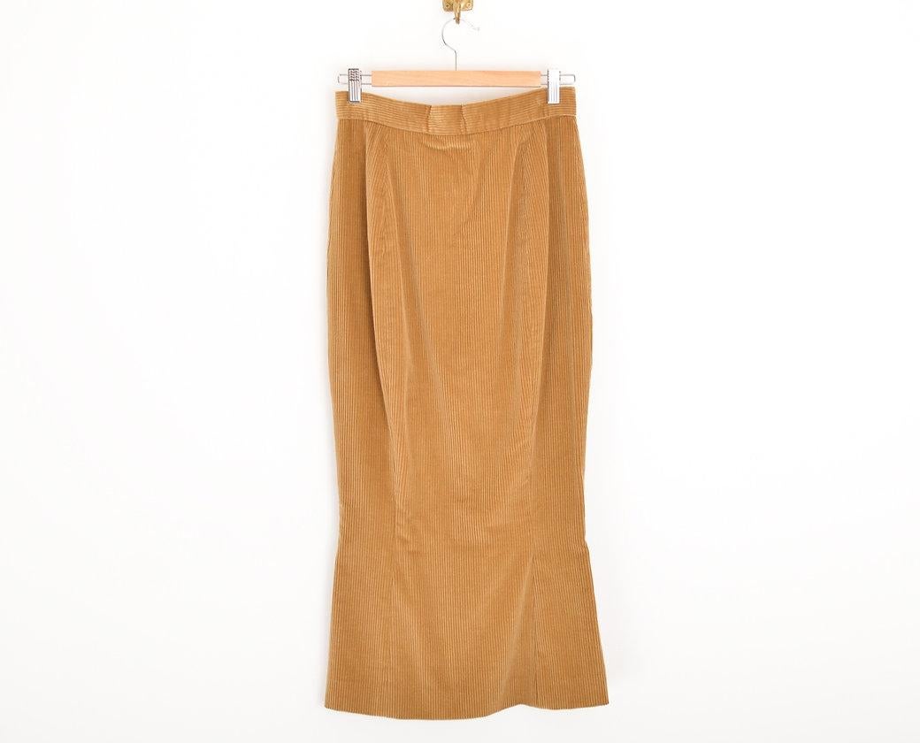 A 1990's Vivienne Westwood high waisted jumbo corduroy skirt, in a caramel / Tan beige colour, with fitted figure hugging shape, High waist band & fishtail hem. 
 
Features;
Jumbo cord
Lightning zip pull
Vivienne Westwood 'ORB' embossed Metal