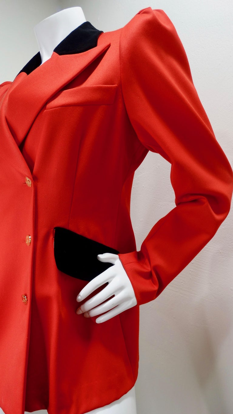 Make a statement with this amazing Vivienne Westwood blazer! Circa 1990s, this vibrant red double breasted blazer is crafted from 100% wool and features leg-o-mutton sleeves, a notched collar, two faux front pockets and black velvet accents.