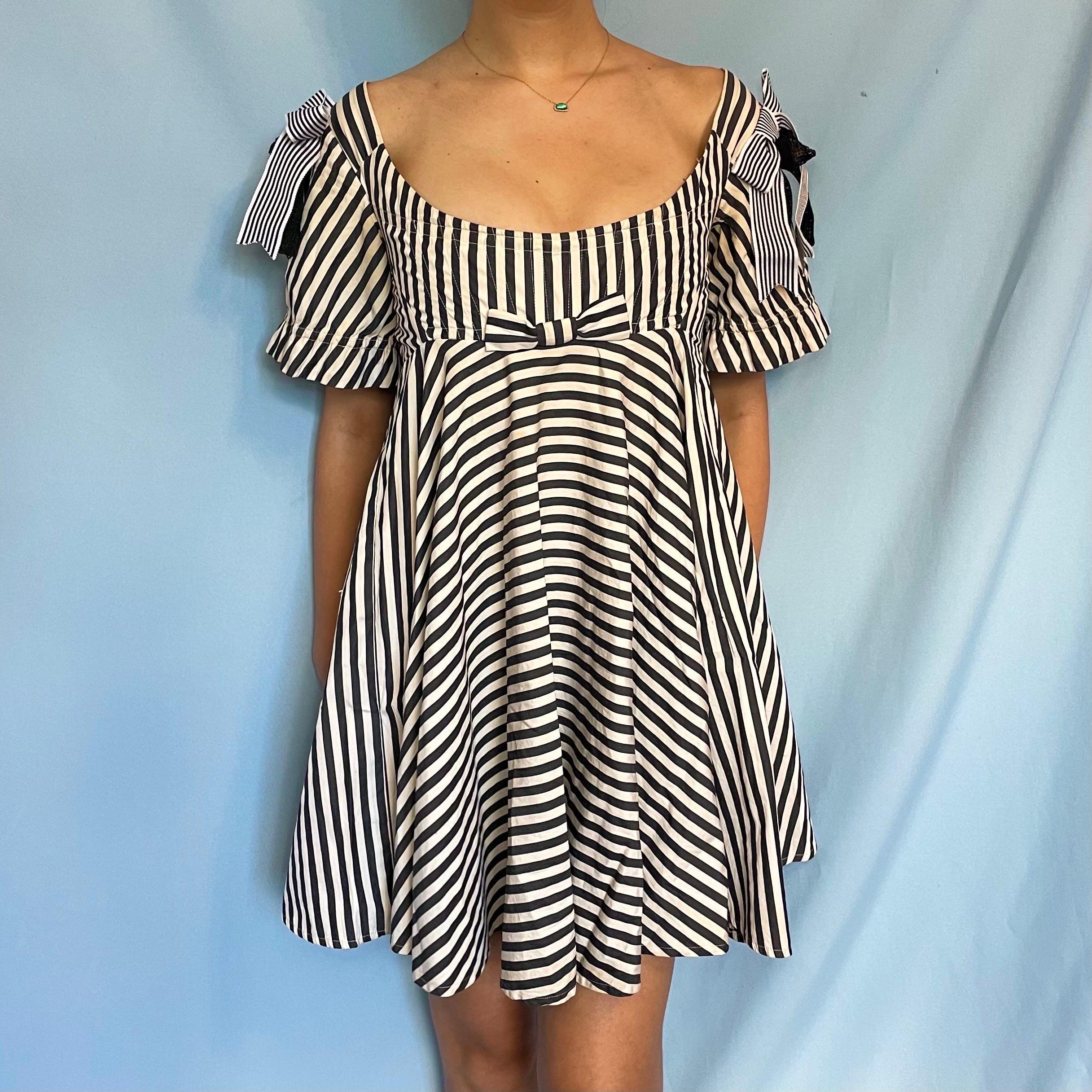Vintage Vivienne Westwood

From Spring 1992

Black & white striped babydoll corseted dress 

Boned corset top inside dress 

Zip up centre back

Size IT 42 / UK 10 / US 6 

Measurements -

Bust of boned corset - 32” 

Length from centre neckline to