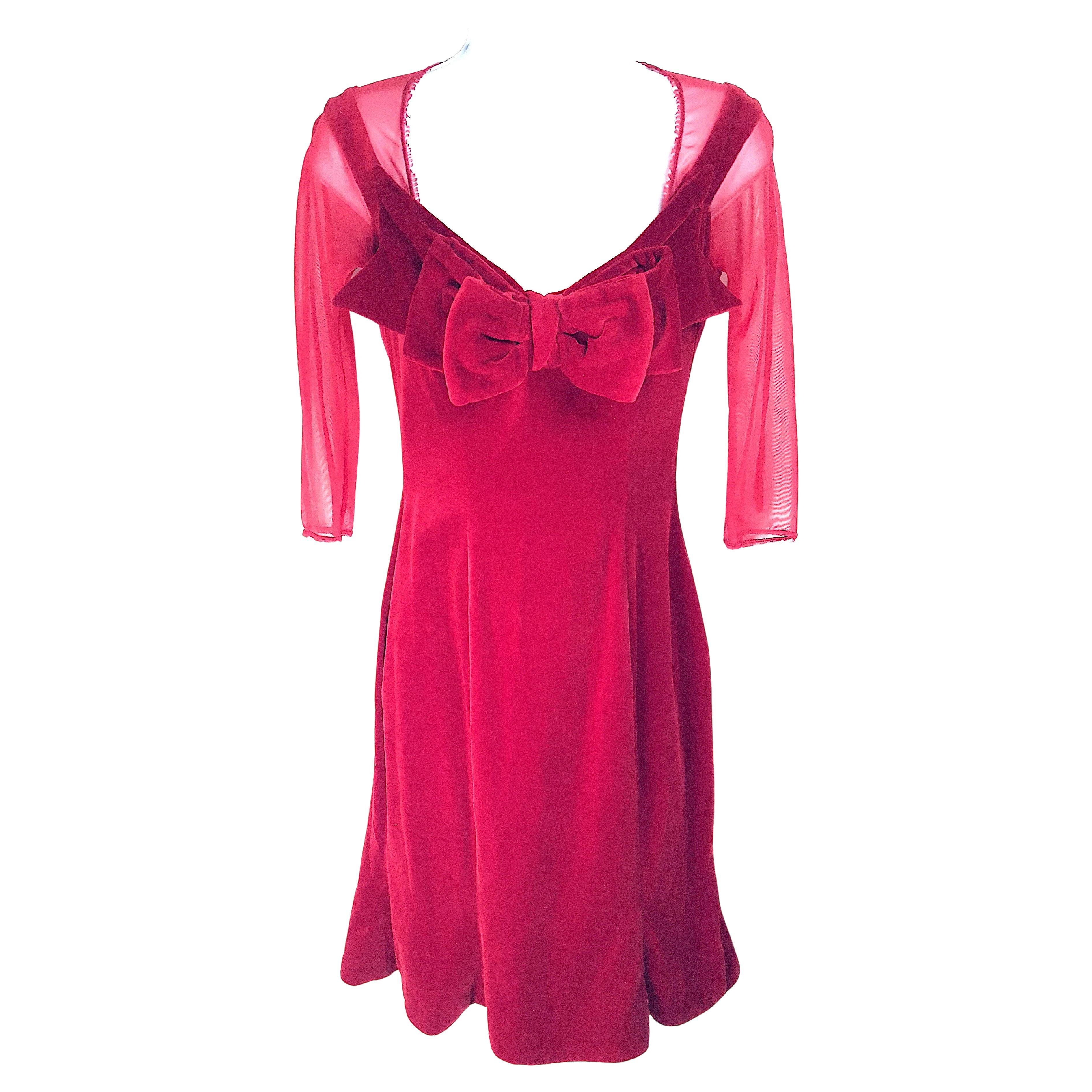 L'inglese Vivienne Westwood (1941-2022) ha disegnato questo abito da sera in velluto rosso a forma di clessidra, con un doppio fiocco fuori misura e un sottofondo di moreschi trasparenti, durante la produzione della sua collezione 