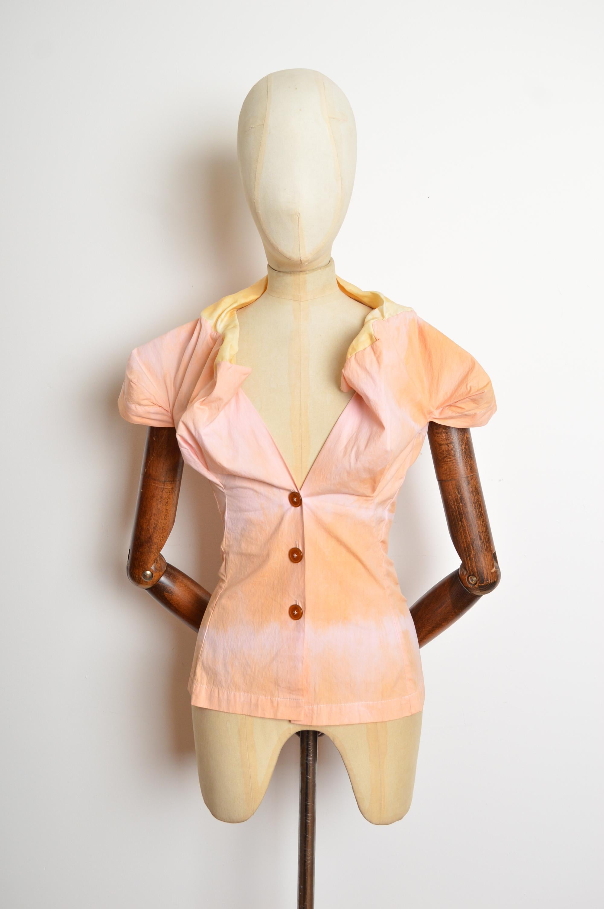 A Superb Vintage Vivienne Westwood Blouse (circa 2007) featuring a tailored silhouette giving an almost corset like flouncy shape, buttons down the front and short capped sleeves. 
Recommended Size; UK 10-12 (the fabric has a little stretch.