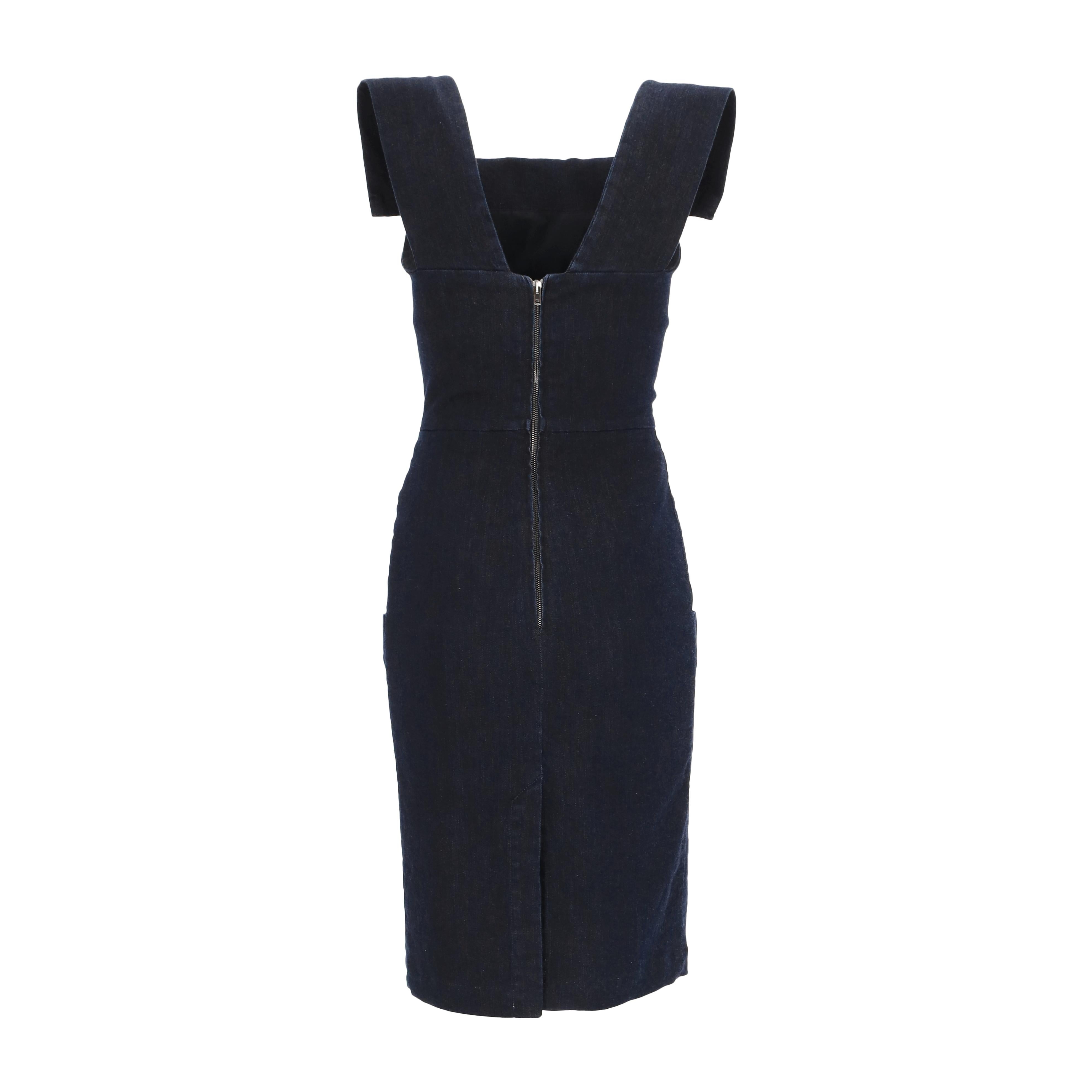 This Vivienne Westwood Anglomania dress is cut to a fitted silhouette and crafted from dark denim fabric. It features box shoulders and a folded neckline that extends to the back in a V shape. The back has a zippered closure and a small slit at the
