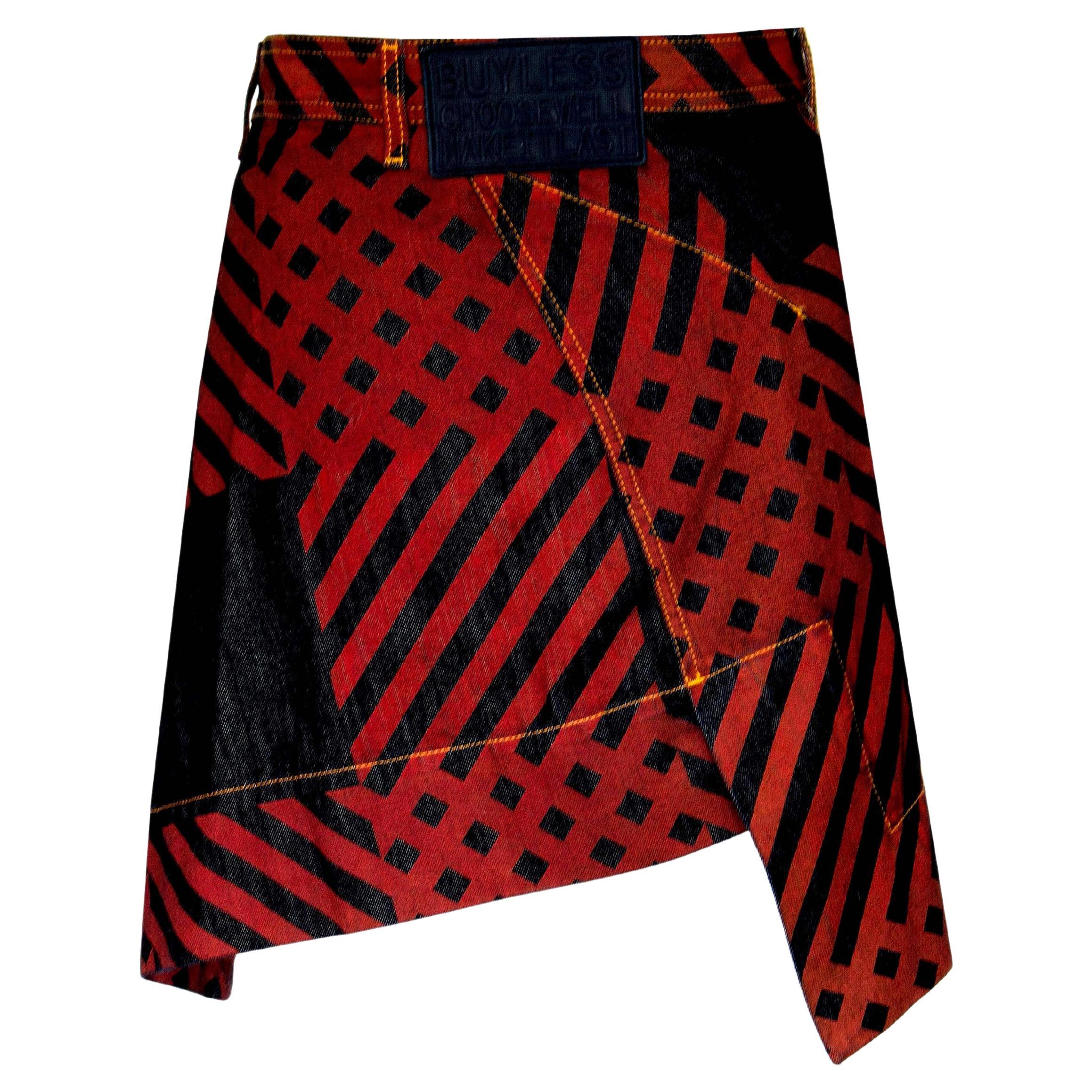 Product Details: Vivienne Westwood - Anglomania - Printed Denim Skirt - Maroon Red + Dark Blue Denim Stripe + Square Print - ‘Buy Less Choose Well Make It Last’ Logo (Back Skirt) - Asymmetric Hemline Detail - Orb Logo Button - 
Label: Vivienne