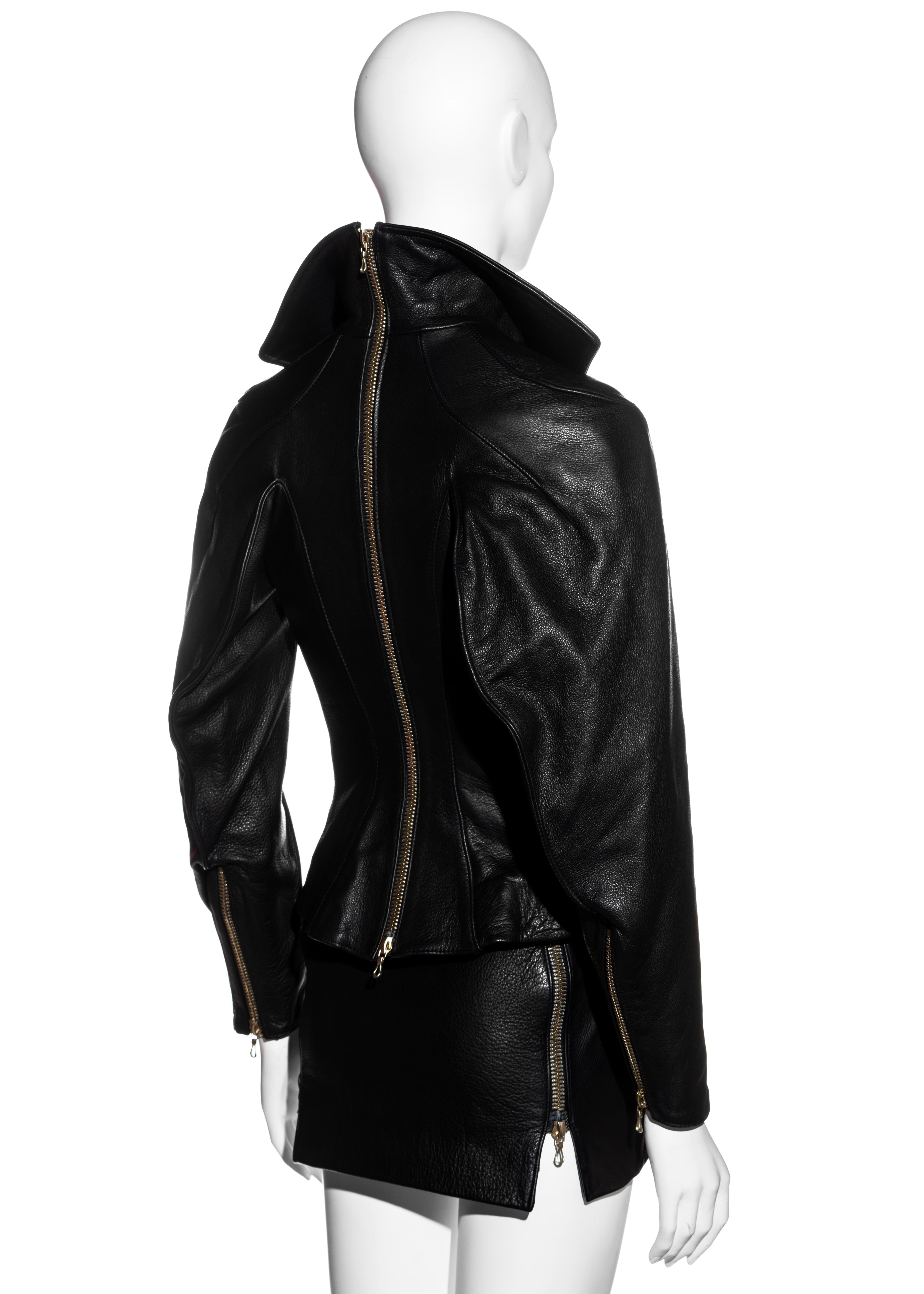 ▪ Vivienne Westwood Couture black leather mini skirt suit
▪ 100% Leather
▪ Corseted Jacket 
▪ Let of mutton sleeves
▪ Double ended metal zipper at centre back 
▪ Quilted satin lining 
▪ Micro mini skirt with two metal zippers at sides 
▪ UK 10 - FR
