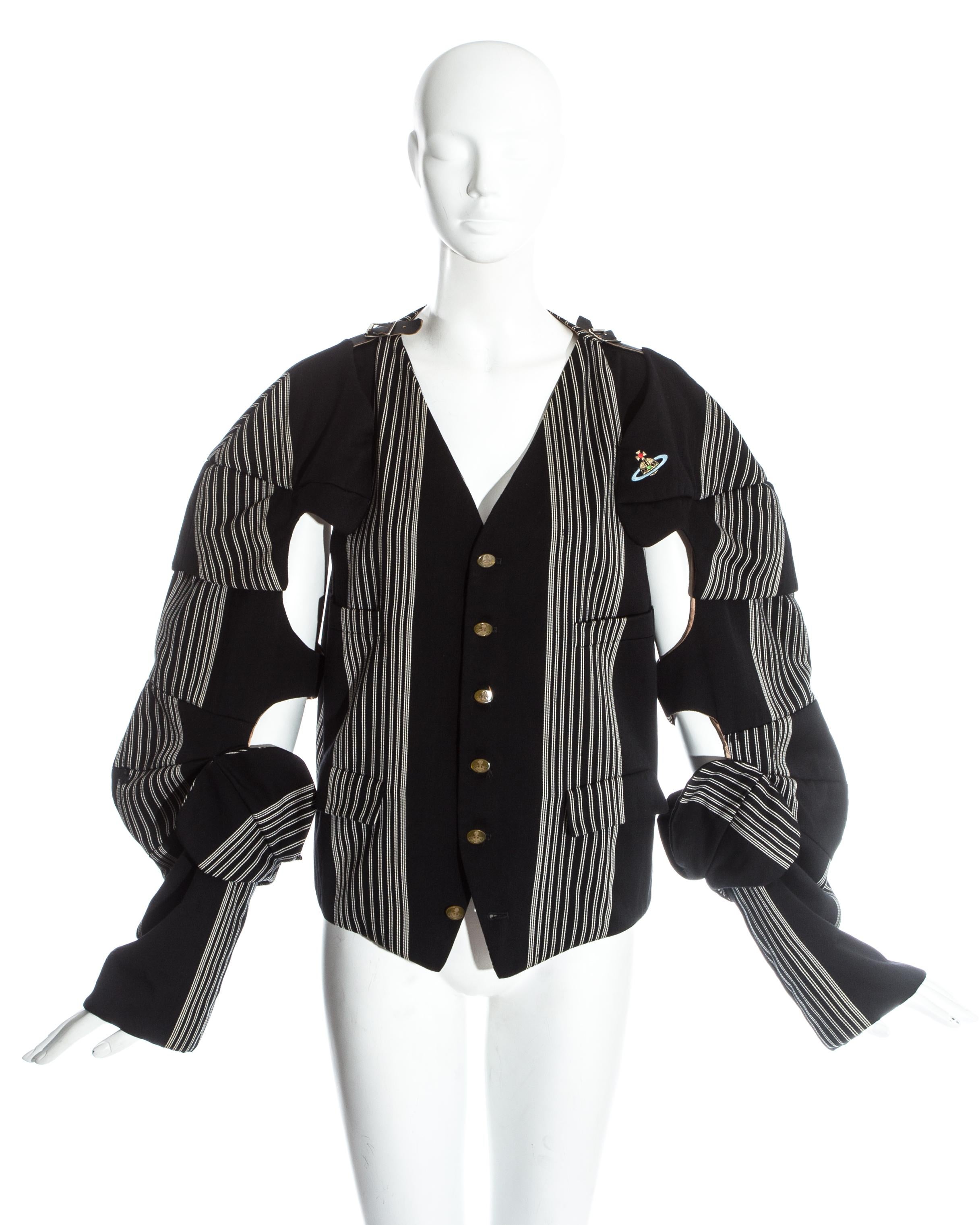 Vivienne Westwood, schwarz-weiß gestreifte Armour Jacke aus Wolle. Abnehmbare Ärmel mit Lederschnallen, gestickter Orb auf der Brust und charakteristische Westwood-Knöpfe.

Zeitmaschine, Herbst-Winter 1989