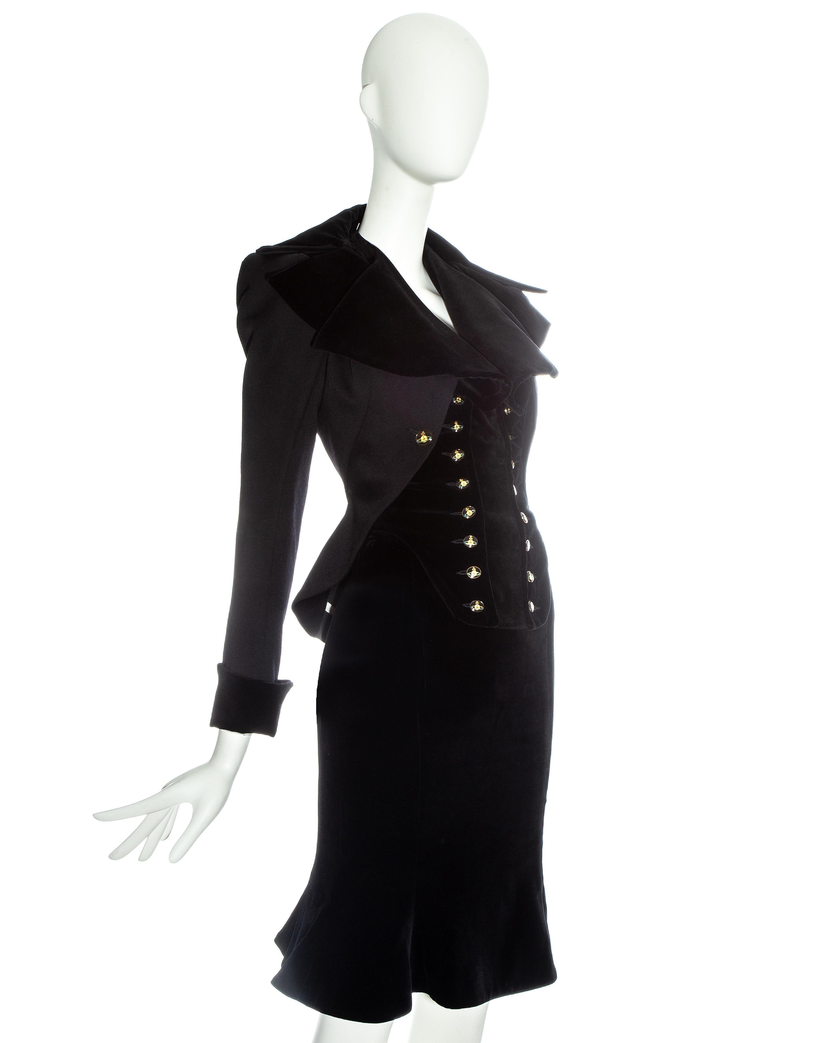 Vivienne Westwood black velvet 'Vive La Cocotte' corseted skirt suit. Riding jacket with detachable corseted waist coat, signature orb button fastenings and puff sleeves. Sold with matching velvet above the knee flounce skirt  

Fall-Winter 1995