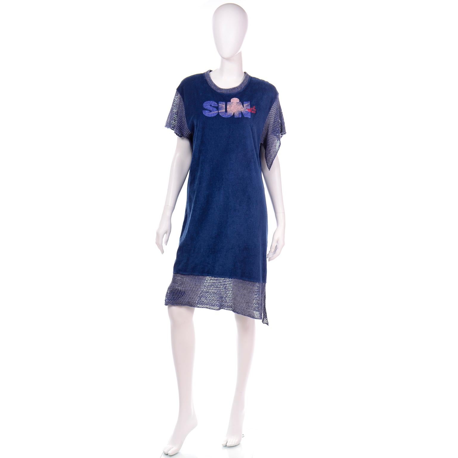 This blue Vivienne Westwood dress is in a blue terry cloth fabric with blue crochet knit trim. The fabric has a brushed or velveteen feel and the dress has a 1970’s style sun on the front with Westwood’s tagline; “Time To Act” with her logo above.