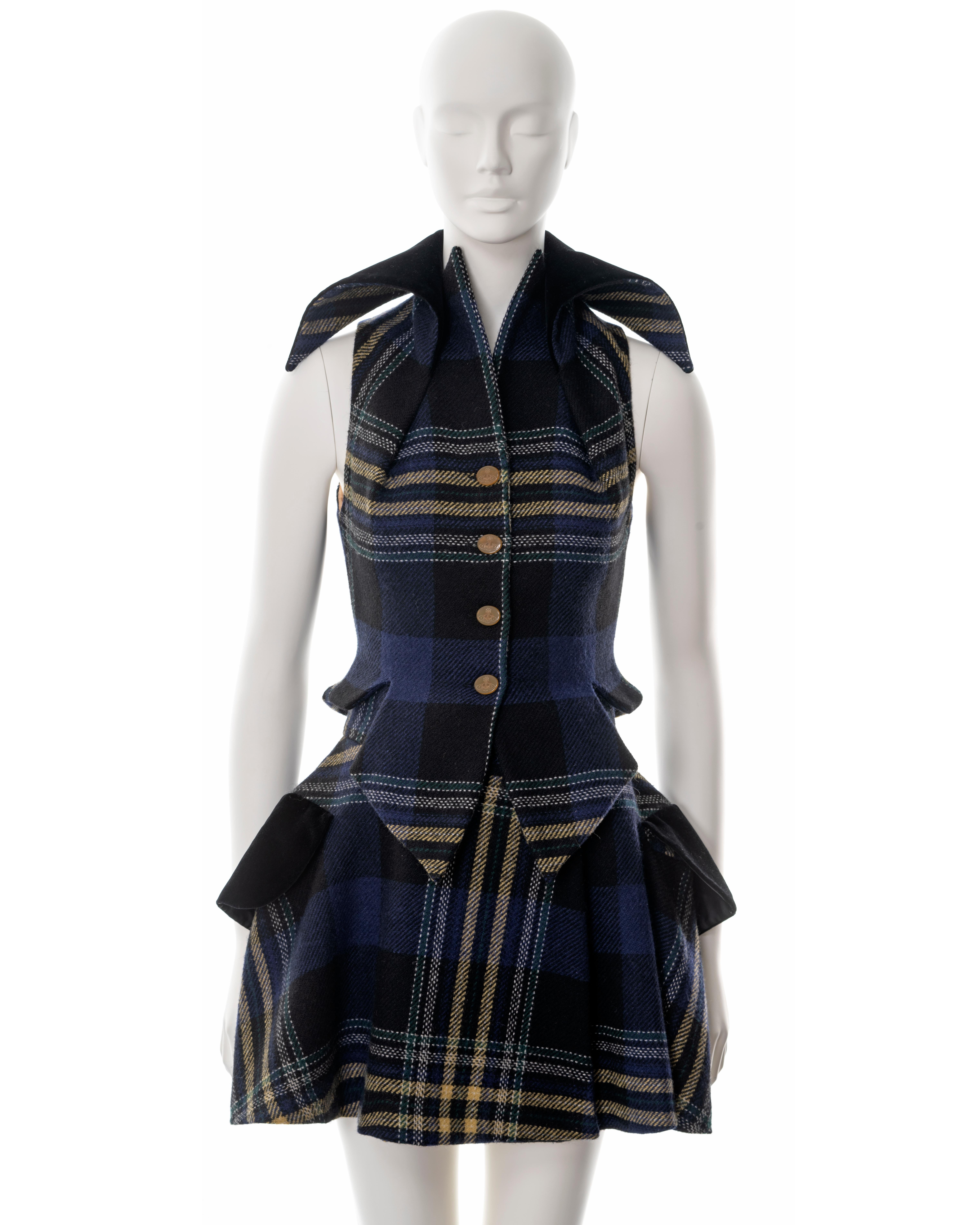 ▪ Vivienne Westwood waistcoat and skirt set
▪ Fall-Winter 1994
▪ Blue, yellow, green and white tartan wool 
▪ Fitted waistcoat 
▪ Orb etched buttons 
▪ Black velvet collar and pocket flaps 
▪ High-waisted mini skirt with wide-cut hips 
▪ IT 40 - FR