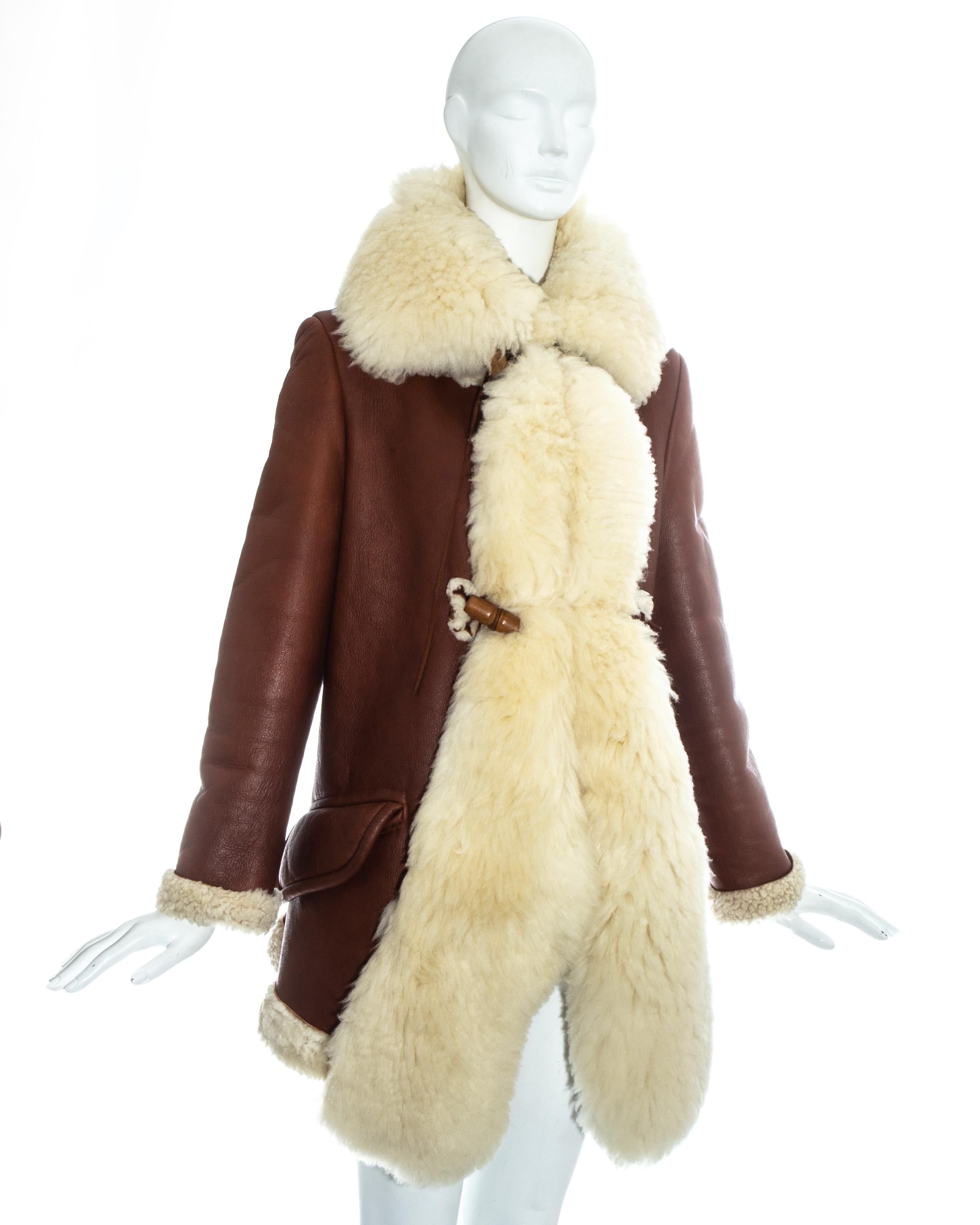 Vivienne Westwood brown leather coat with oversized cream shearling collar and wood toggle and leather string fastenings.

Fall-Winter 1991